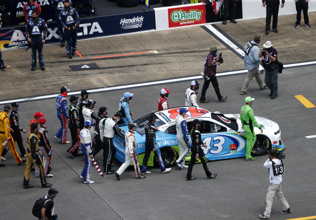 TALLADEGA, ALABAMA - JUNE 22: NASCAR drivers push the #43 Victory Junction Chevrolet, driven by Bubba Wallace, to the front of the grid as a sign of solidarity with the driver prior to the NASCAR Cup Series GEICO 500 at Talladega Superspeedway on June 22, 2020 in Talladega, Alabama. A noose was found in the garage stall of NASCAR driver Bubba Wallace at Talladega Superspeedway a week after the organization banned the Confederate flag at its facilities. (Photo by Brian Lawdermilk/Getty Images) | Getty Images