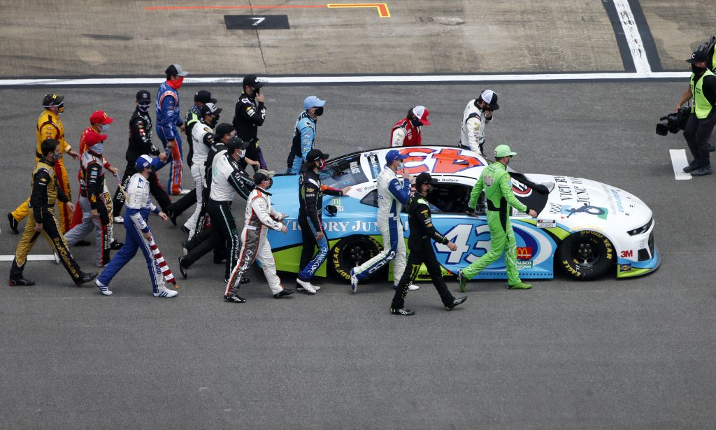 TALLADEGA, ALABAMA - JUNE 22: NASCAR drivers push the #43 Victory Junction Chevrolet, driven by Bubba Wallace, to the front of the grid as a sign of solidarity with the driver prior to the NASCAR Cup Series GEICO 500 at Talladega Superspeedway on June 22, 2020 in Talladega, Alabama. A noose was found in the garage stall of NASCAR driver Bubba Wallace at Talladega Superspeedway a week after the organization banned the Confederate flag at its facilities. (Photo by Brian Lawdermilk/Getty Images) | Getty Images