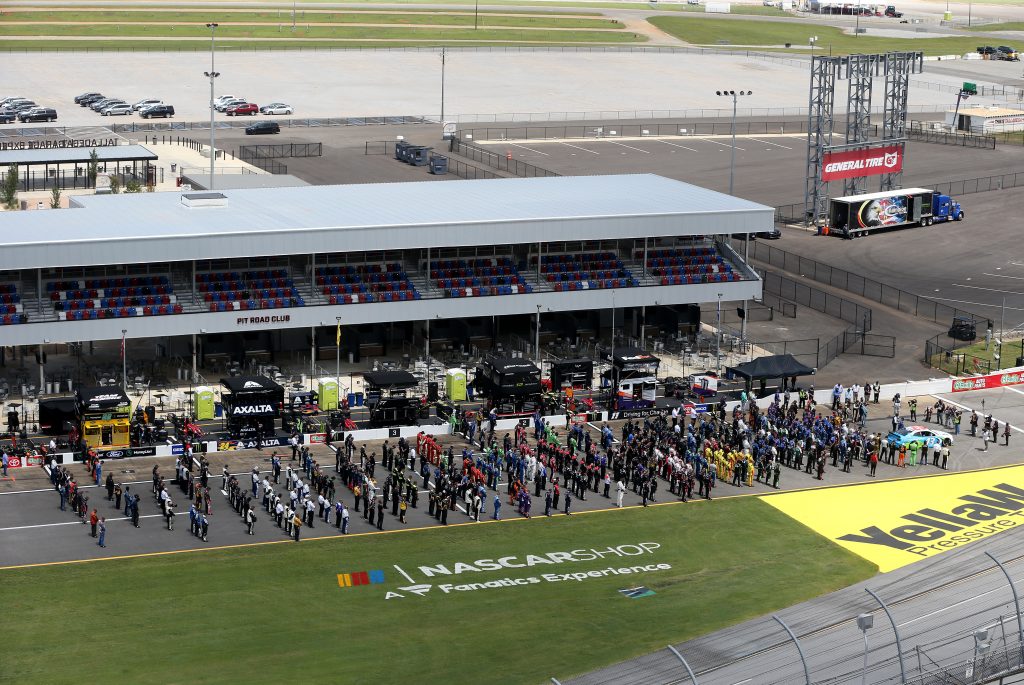 TALLADEGA, ALABAMA - JUNE 22: NASCAR drivers stand in solidarity with Bubba Wallace, driver of the #43 Victory Junction Chevrolet, during pre-race ceremonies prior to the NASCAR Cup Series GEICO 500 at Talladega Superspeedway on June 22, 2020 in Talladega, Alabama. A noose was found in the garage stall of NASCAR driver Bubba Wallace at Talladega Superspeedway a week after the organization banned the Confederate flag at its facilities. (Photo by Brian Lawdermilk/Getty Images) | Getty Images