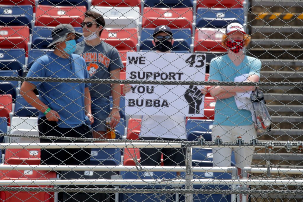 TALLADEGA, ALABAMA - JUNE 22: Fans hold a sign in support of Bubba Wallace, driver of the #43 Victory Junction Chevrolet, prior to the NASCAR Cup Series GEICO 500 at Talladega Superspeedway on June 22, 2020 in Talladega, Alabama. A noose was found in the garage stall of NASCAR driver Bubba Wallace at Talladega Superspeedway a week after the organization banned the Confederate flag at its facilities. (Photo by Chris Graythen/Getty Images) | Getty Images