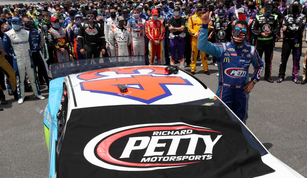 TALLADEGA, ALABAMA - JUNE 22: NASCAR drivers stand in solidarity with Bubba Wallace, driver of the #43 Victory Junction Chevrolet, during pre-race ceremonies prior to the NASCAR Cup Series GEICO 500 at Talladega Superspeedway on June 22, 2020 in Talladega, Alabama. A noose was found in the garage stall of NASCAR driver Bubba Wallace at Talladega Superspeedway a week after the organization banned the Confederate flag at its facilities. (Photo by Chris Graythen/Getty Images) | Getty Images