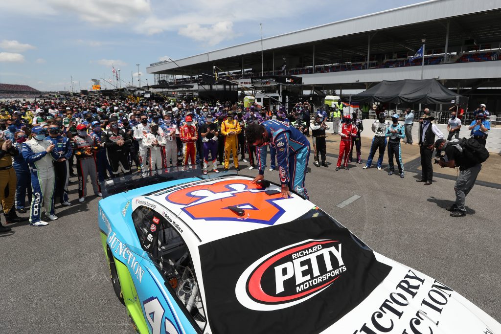 TALLADEGA, ALABAMA - JUNE 22: NASCAR drivers stand in solidarity with Bubba Wallace, driver of the #43 Victory Junction Chevrolet, during pre-race ceremonies prior to the NASCAR Cup Series GEICO 500 at Talladega Superspeedway on June 22, 2020 in Talladega, Alabama. A noose was found in the garage stall of NASCAR driver Bubba Wallace at Talladega Superspeedway a week after the organization banned the Confederate flag at its facilities. (Photo by Chris Graythen/Getty Images) | Getty Images