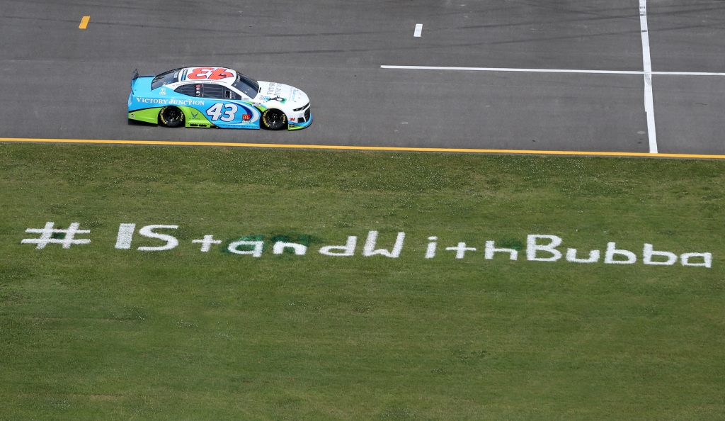 TALLADEGA, ALABAMA - JUNE 22: Bubba Wallace, driver of the #43 Victory Junction Chevrolet, drives past the #IStandWithBubba stencil on the field prior to the NASCAR Cup Series GEICO 500 at Talladega Superspeedway on June 22, 2020 in Talladega, Alabama. A noose was found in the garage stall of NASCAR driver Bubba Wallace at Talladega Superspeedway a week after the organization banned the Confederate flag at its facilities. (Photo by Brian Lawdermilk/Getty Images) | Getty Images