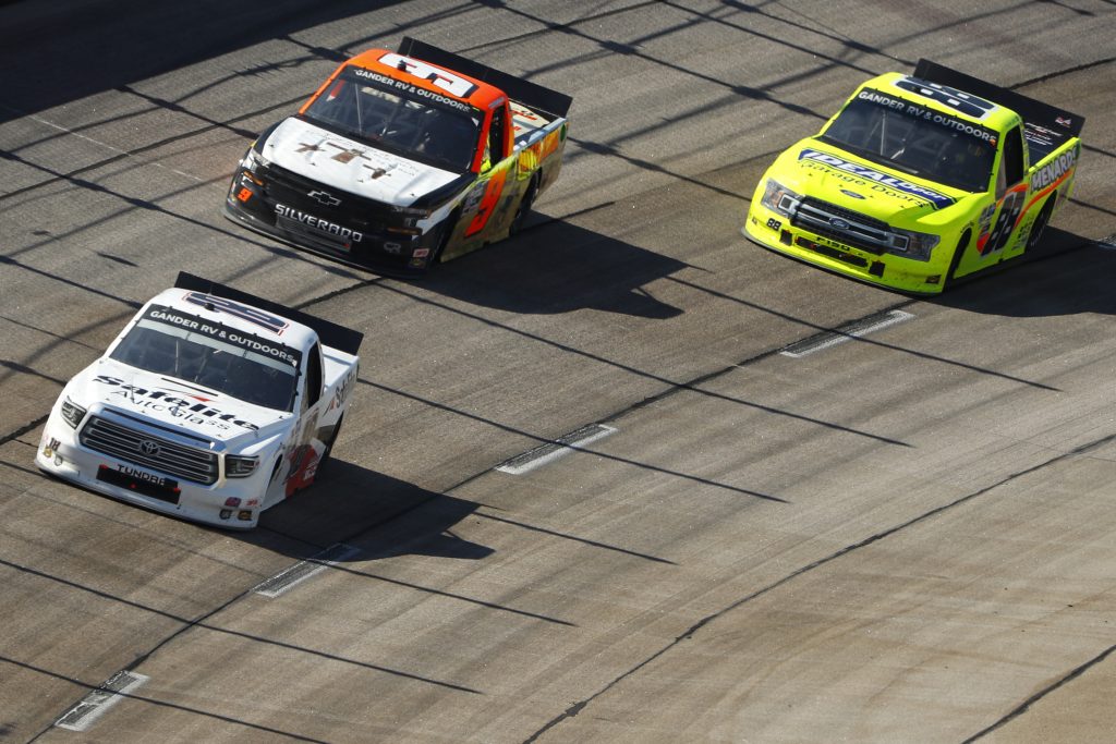 DARLINGTON, SOUTH CAROLINA - SEPTEMBER 06: Christian Eckes, driver of the #18 Safelite AutoGlass Toyota, Codie Rohrbaugh, driver of the #9 Pray for Joshua Chevrolet, and Matt Crafton, driver of the #88 Ideal Door/Menards Ford, race during the NASCAR Gander Outdoors Truck Series South Carolina Education Lottery 200 at Darlington Raceway on September 06, 2020 in Darlington, South Carolina. (Photo by Chris Keane/Getty Images) | Getty Images