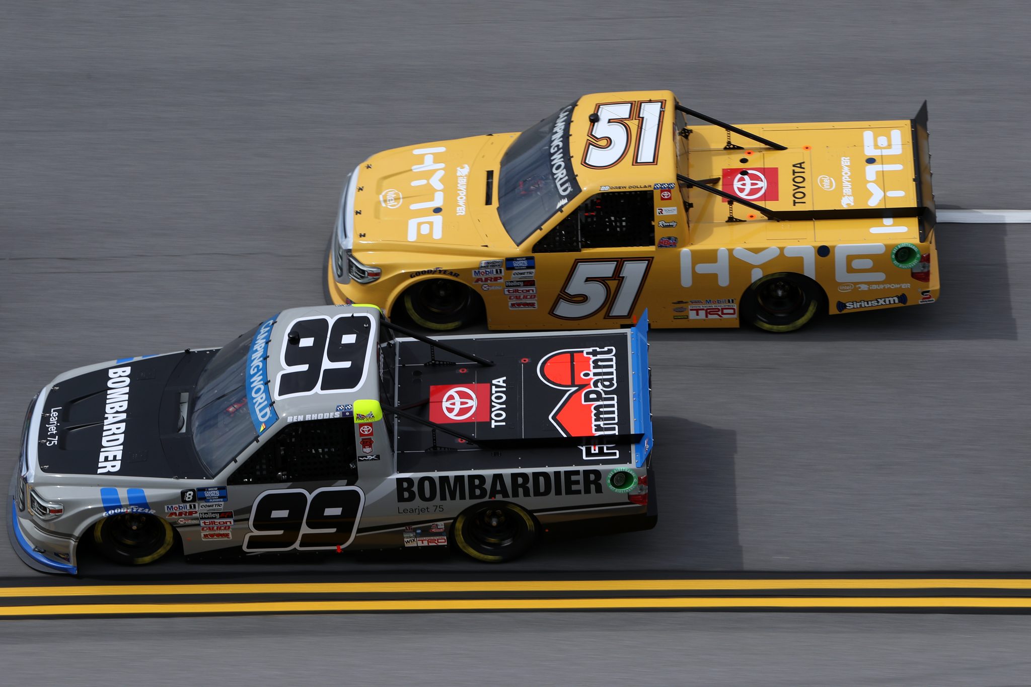 TALLADEGA, ALABAMA - OCTOBER 02: Drew Dollar, driver of the #51 HYTE Toyota, and Ben Rhodes, driver of the #99 Bombardier LearJet 75 Toyota, race during the NASCAR Camping World Truck Series Chevrolet Silverado 250 at Talladega Superspeedway on October 02, 2021 in Talladega, Alabama. (Photo by Sean Gardner/Getty Images) | Getty Images