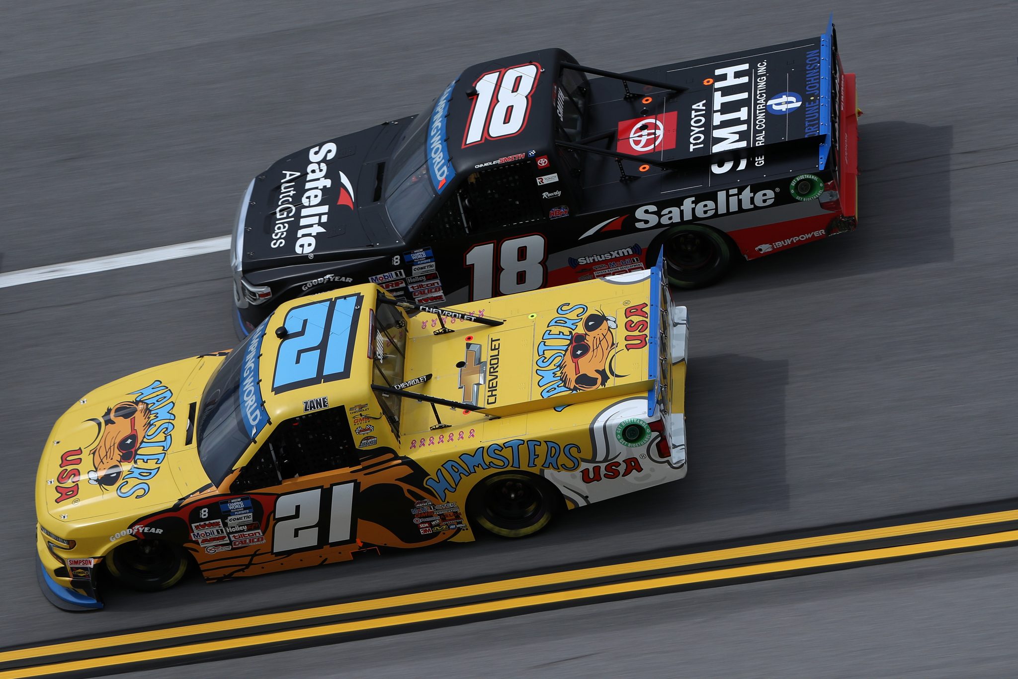 TALLADEGA, ALABAMA - OCTOBER 02: Zane Smith, driver of the #21 Hamsters USA Chevrolet, and Chandler Smith, driver of the #18 Safelite AutoGlass Toyota, race during the NASCAR Camping World Truck Series Chevrolet Silverado 250 at Talladega Superspeedway on October 02, 2021 in Talladega, Alabama. (Photo by Sean Gardner/Getty Images) | Getty Images