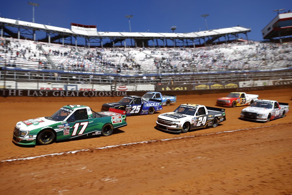 BRISTOL, TENNESSEE - MARCH 29: Kevin Harvick, driver of the #17 Hunt Brothers Pizza Ford, Raphael Lessard, driver of the #24 Chevy Accessories Chevrolet, and Timothy Peters, driver of the #25 Rackley Roofing Chevrolet, race during the NASCAR Camping World Truck Series Pinty's Truck Race on Dirt at Bristol Motor Speedway on March 29, 2021 in Bristol, Tennessee. (Photo by Chris Graythen/Getty Images) | Getty Images