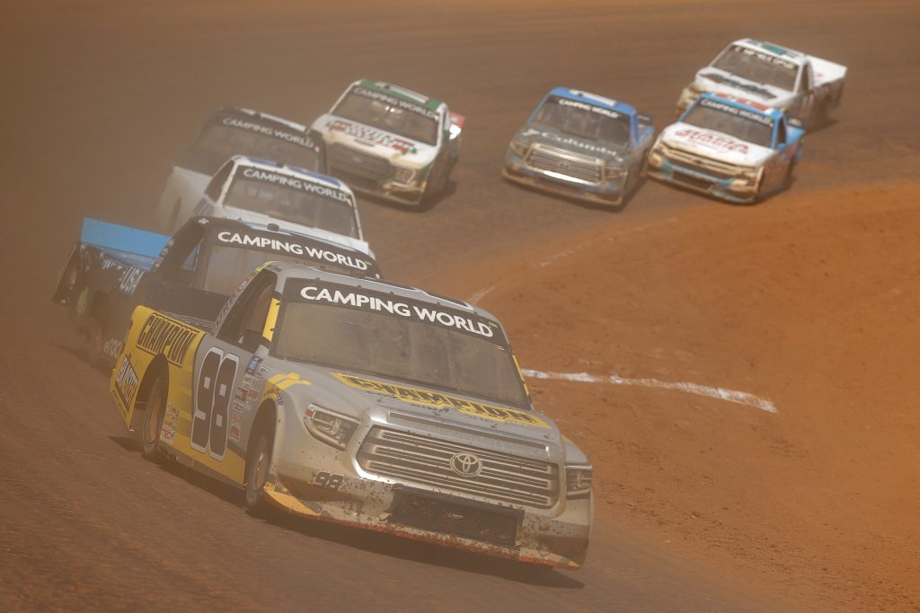 BRISTOL, TENNESSEE - MARCH 29: Grant Enfinger, driver of the #98 Champion/Curb Records Toyota, leads the field during the NASCAR Camping World Truck Series Pinty's Truck Race on Dirt at Bristol Motor Speedway on March 29, 2021 in Bristol, Tennessee. (Photo by Jared C. Tilton/Getty Images) | Getty Images