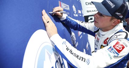 TALLADEGA, ALABAMA - OCTOBER 01: Christopher Bell, driver of the #20 Sirius XM Toyota, signs the Busch Light Pole Award backdrop after winning the pole award during qualifying for the NASCAR Cup Series YellaWood 500 at Talladega Superspeedway on October 01, 2022 in Talladega, Alabama. (Photo by Sean Gardner/Getty Images) | Getty Images