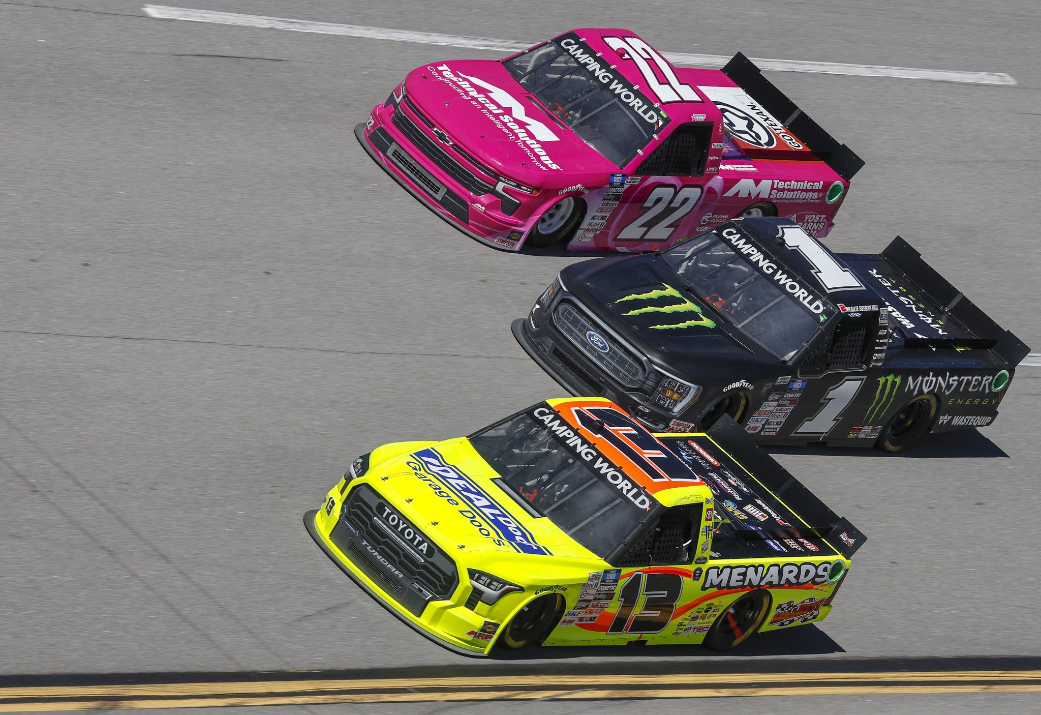 TALLADEGA, ALABAMA - OCTOBER 01: Austin Wayne Self, driver of the #22 AM Technical Solutions Chevrolet, Hailie Deegan, driver of the #1 Monster Energy Ford, and Johnny Sauter, driver of the #13 Ideal Door/Menards Toyota, race during the NASCAR Camping World Truck Series Chevy Silverado 250 at Talladega Superspeedway on October 01, 2022 in Talladega, Alabama. (Photo by Sean Gardner/Getty Images) | Getty Images