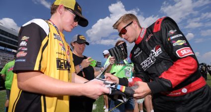 FORT WORTH, TEXAS - SEPTEMBER 25: Garrett Smithley, driver of the #15 Trophy Tractor Ford, signs an autographs for a NASCAR fan during pre-race ceremonies prior to the NASCAR Cup Series Auto Trader EchoPark Automotive 500 at Texas Motor Speedway on September 25, 2022 in Fort Worth, Texas. (Photo by Jonathan Bachman/Getty Images) | Getty Images