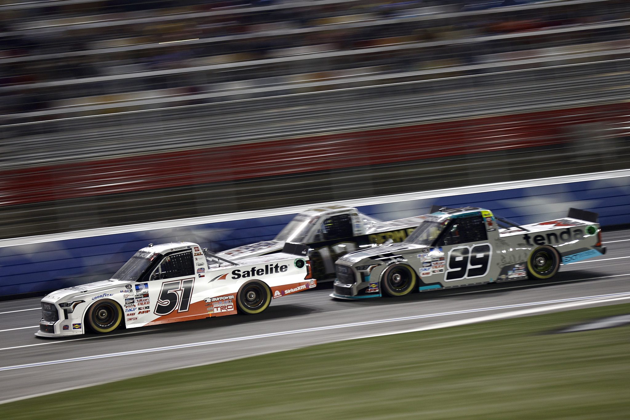 CONCORD, NORTH CAROLINA - MAY 27: Kyle Busch, driver of the #51 Safelite Toyota, and Ben Rhodes, driver of the #99 Tenda Toyota, race during the NASCAR Camping World Truck Series North Carolina Education Lottery 200 at Charlotte Motor Speedway on May 27, 2022 in Concord, North Carolina. (Photo by Jared C. Tilton/Getty Images) | Getty Images