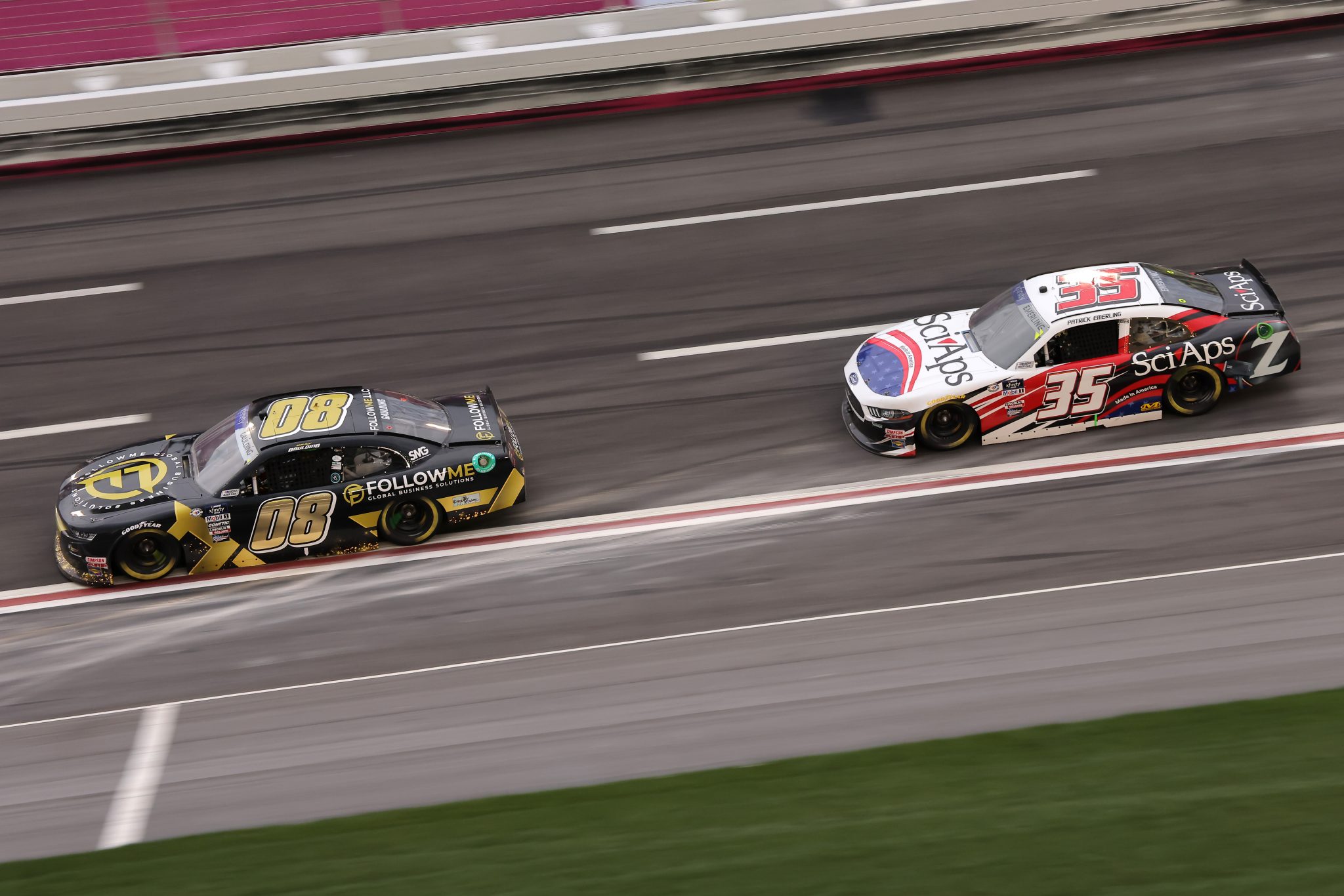 HAMPTON, GEORGIA - MARCH 18: Gray Gaulding, driver of the #08 FollowMe Global Bus. Solutions Chevrolet, and Patrick Emerling, driver of the #35 Sci Aps Ford, race during the NASCAR Xfinity Series RAPTOR 250 at Atlanta Motor Speedway on March 18, 2023 in Hampton, Georgia. (Photo by Jonathan Bachman/Getty Images) | Getty Images