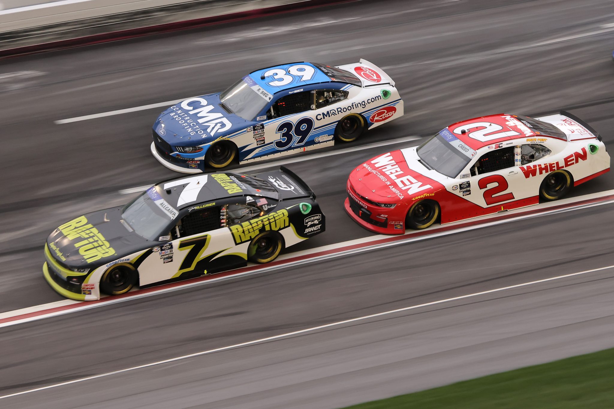 HAMPTON, GEORGIA - MARCH 18: Justin Allgaier, driver of the #7 RaptorTough.com Chevrolet, Ryan Sieg, driver of the #39 CMRroofing.com Ford, and Sheldon Creed, driver of the #2 Whelen Chevrolet, race during the NASCAR Xfinity Series RAPTOR 250 at Atlanta Motor Speedway on March 18, 2023 in Hampton, Georgia. (Photo by Jonathan Bachman/Getty Images) | Getty Images