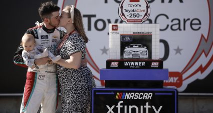 RICHMOND, VIRGINIA - APRIL 01: Chandler Smith, driver of the #16 Quick Tie Products Inc. Chevrolet, celebrates with a kiss from his wife, Kenzie Smith, holding son Chandler Smith Jr. in victory lane after winning the NASCAR Xfinity Series ToyotaCare 250 at Richmond Raceway on April 01, 2023 in Richmond, Virginia. (Photo by Jared C. Tilton/Getty Images) | Getty Images