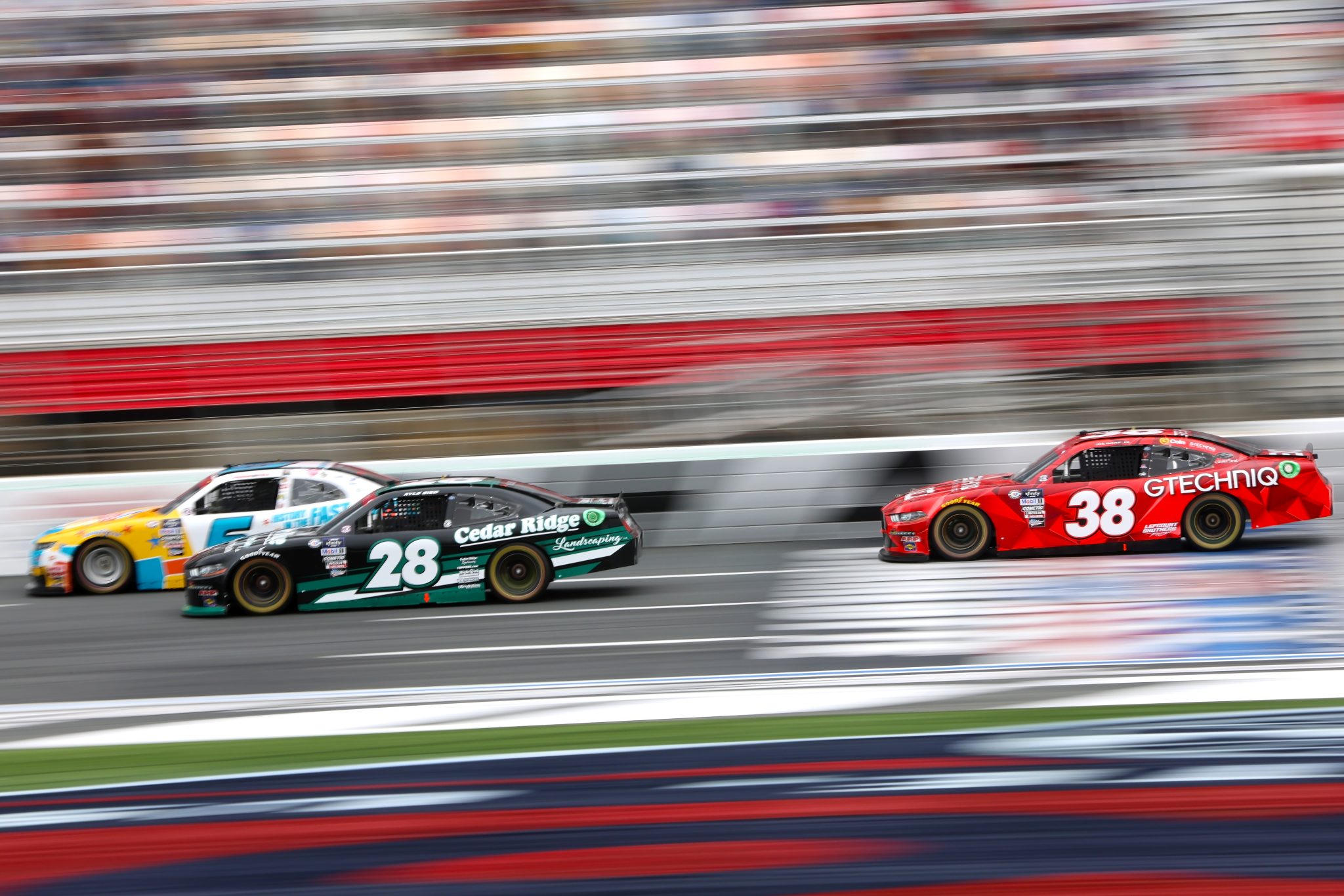 CONCORD, NORTH CAROLINA - MAY 29: Kyle Sieg, driver of the #28 Cedar Ridge Landscaping Ford, Brennan Poole, driver of the #6 Moonshine & Motorsports Trail Chevrolet, and Joe Graf Jr., driver of the #38 GTECHNIQ Ford, race during the NASCAR Xfinity Series Alsco Uniforms 300 at Charlotte Motor Speedway on May 29, 2023 in Concord, North Carolina. (Photo by David Jensen/Getty Images) | Getty Images