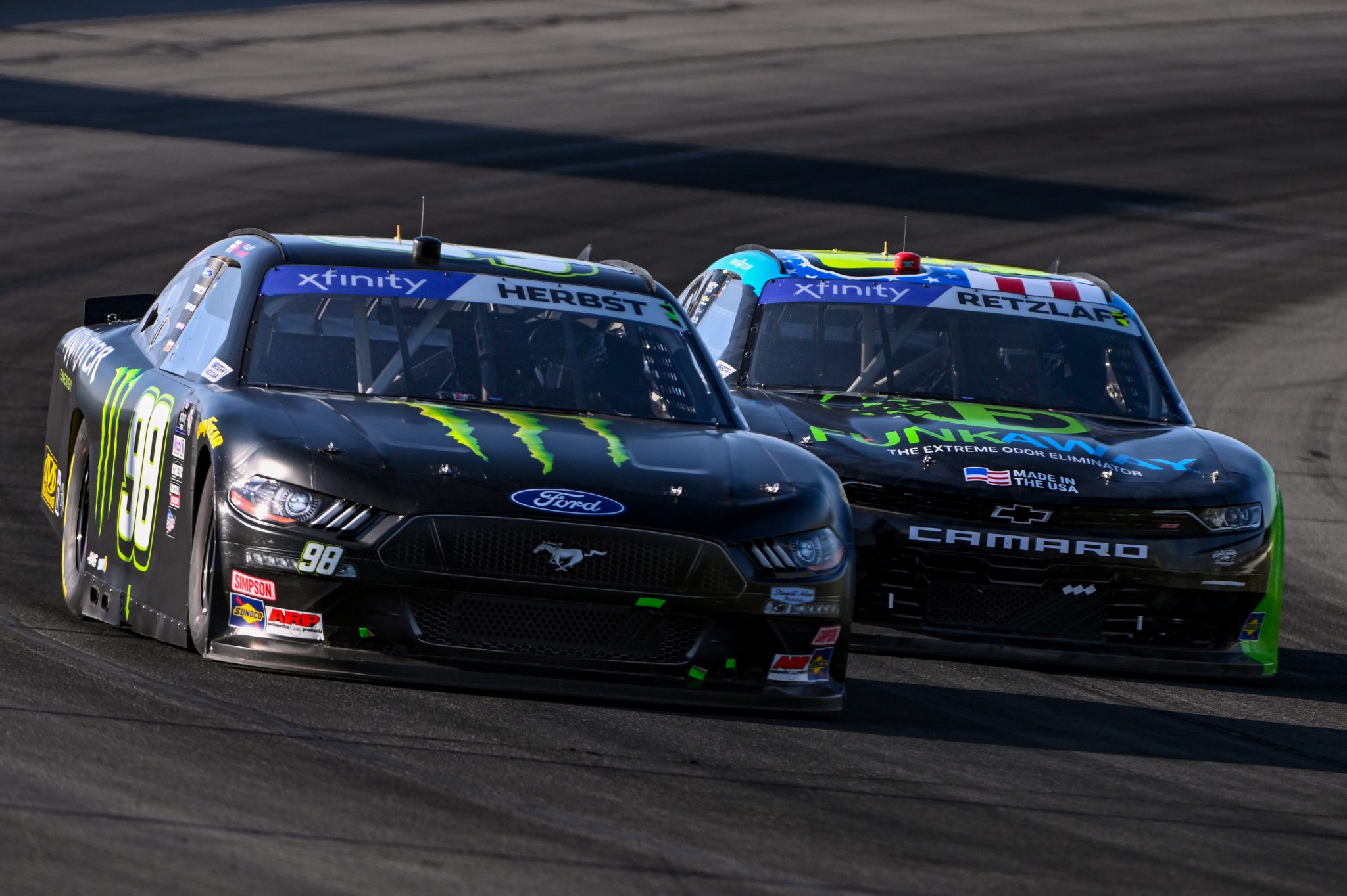 LONG POND, PENNSYLVANIA - JULY 22: Riley Herbst, driver of the #98 Monster Energy Ford, and Parker Retzlaff, driver of the #31 FunkAway Chevrolet, race during the NASCAR Xfinity Series Pocono 225 at Pocono Raceway on July 22, 2023 in Long Pond, Pennsylvania. (Photo by Logan Riely/Getty Images) | Getty Images