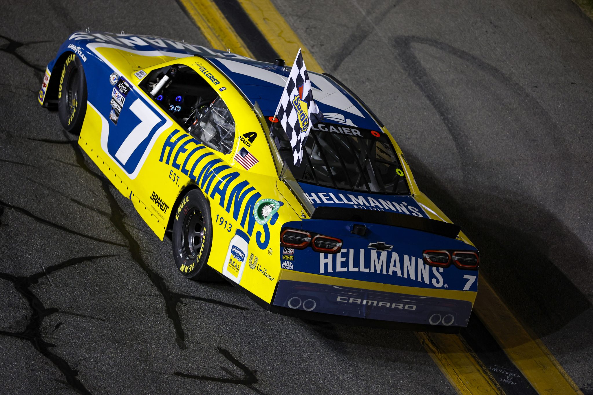 DAYTONA BEACH, FLORIDA - AUGUST 25: Justin Allgaier, driver of the #7 Hellmann's Chevrolet, drives with the checkered flag after winning the NASCAR Xfinity Series Wawa 250 powered by Coca-Cola at Daytona International Speedway on August 25, 2023 in Daytona Beach, Florida. (Photo by James Gilbert/Getty Images) | Getty Images