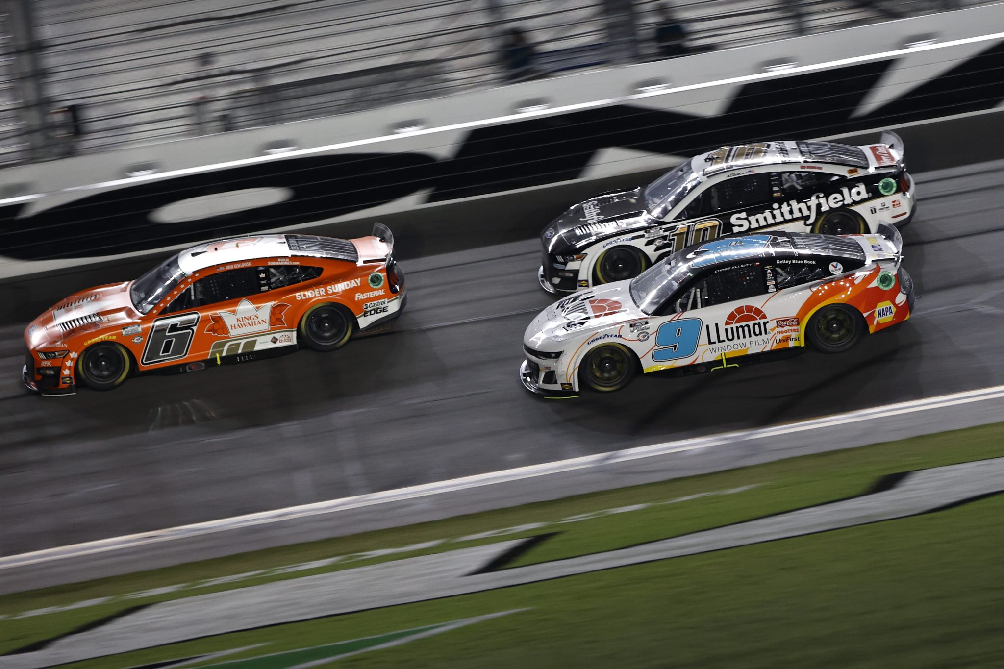 DAYTONA BEACH, FLORIDA - AUGUST 26: Brad Keselowski, driver of the #6 King's Hawaiian Ford, Chase Elliott, driver of the #9 LLumar Chevrolet, and Aric Almirola, driver of the #10 Smithfield Ford, race during the NASCAR Cup Series Coke Zero Sugar 400 at Daytona International Speedway on August 26, 2023 in Daytona Beach, Florida. (Photo by Chris Graythen/Getty Images) | Getty Images
