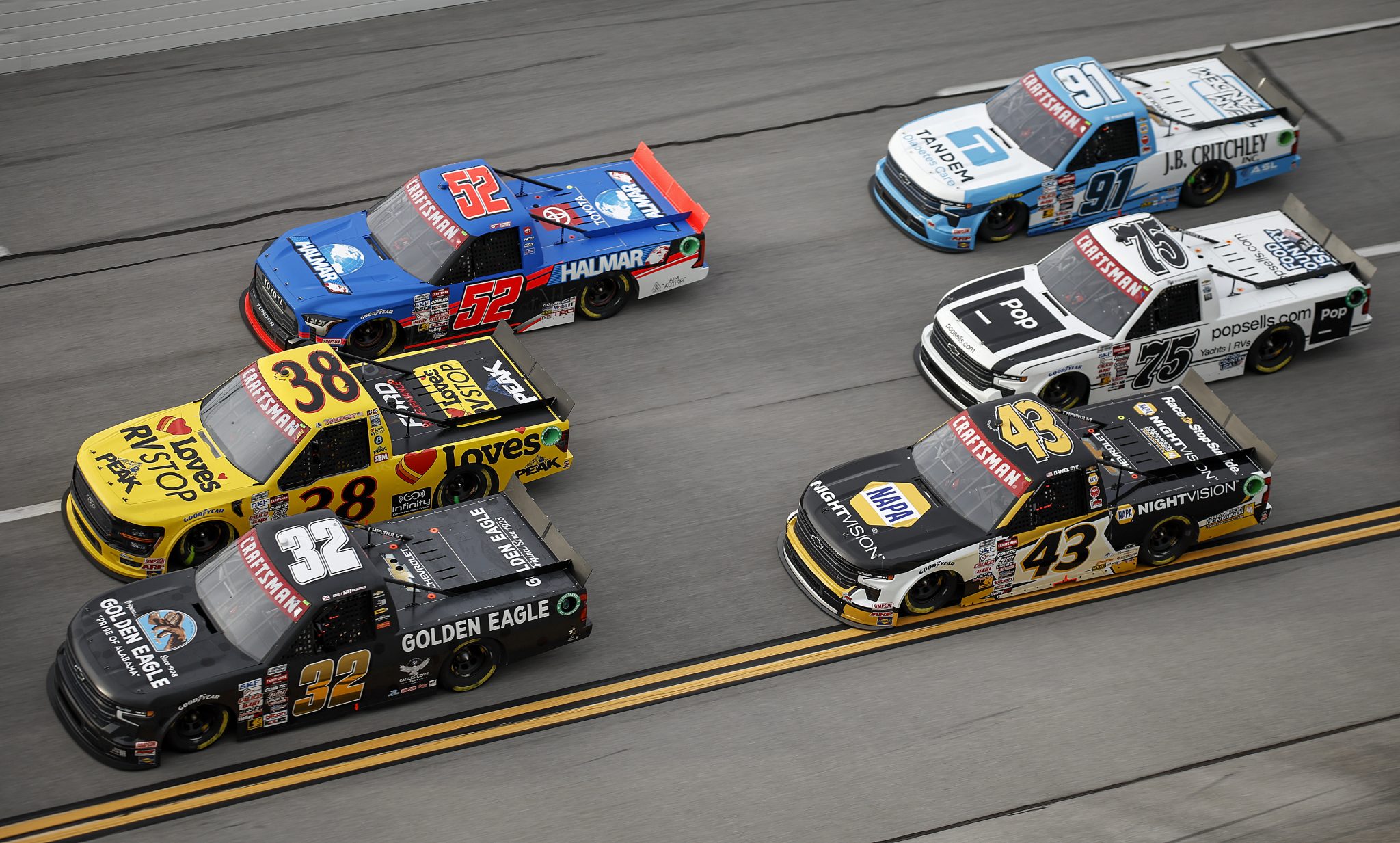 TALLADEGA, ALABAMA - OCTOBER 04: Bret Holmes, driver of the #32 Golden Eagle Chevrolet, Layne Riggs, driver of the #38 Love's Travel Stops Ford, Stewart Friesen, driver of the #52 Halmar International Toyota, Daniel Dye, driver of the #43 NAPA Nightvision Chevrolet, Stefan Parsons, driver of the #75 popsells.com Chevrolet, and Ryan Reed, driver of the #91 Tandem Diabetes Care Chevrolet, race during the NASCAR Craftsman Truck Series Love's RV Stop 225 at Talladega Superspeedway on October 04, 2024 in Talladega, Alabama. (Photo by Chris Graythen/Getty Images) | Getty Images