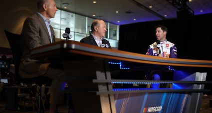 DAYTONA BEACH, FLORIDA - FEBRUARY 16: Denny Hamlin, driver of the #11 FedEx Express Toyota, speaks with NASCAR analyst Larry McReynolds (C) and NASCAR Race Hub host Adam Alexander during the NASCAR Cup Series 64th Annual Daytona 500 Media Day at Daytona International Speedway on February 16, 2022 in Daytona Beach, Florida. (Photo by James Gilbert/Getty Images) | Getty Images