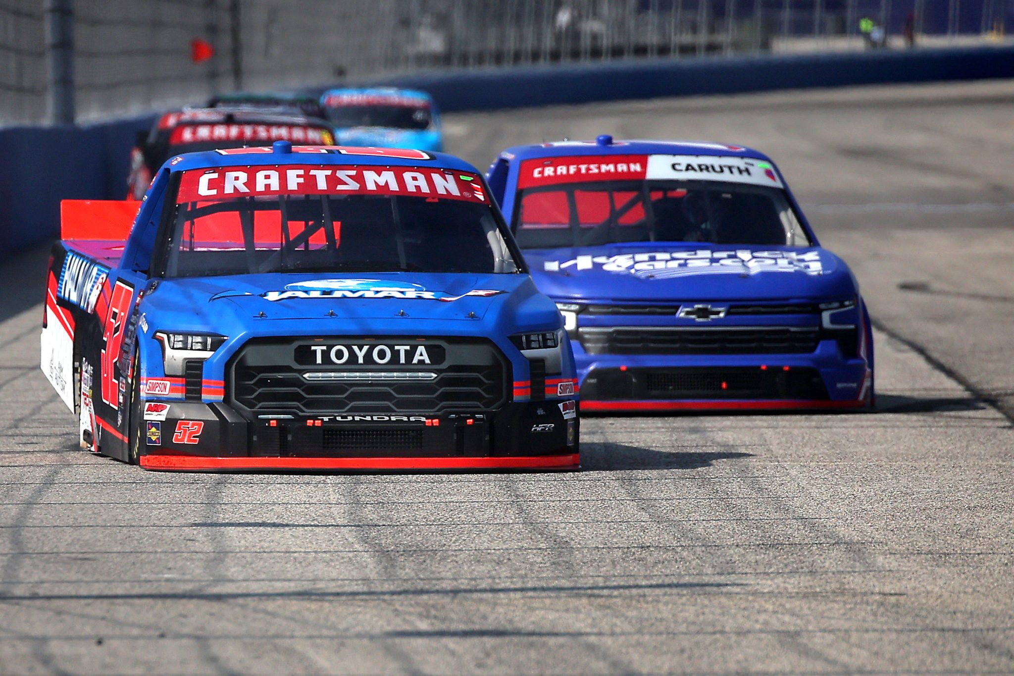 WEST ALLIS, WISCONSIN - AUGUST 25: Stewart Friesen, driver of the #52 Halmar International Toyota, and Rajah Caruth, driver of the #71 HendrickCars.com Chevrolet, race during the NASCAR Craftsman Truck Series The Milwaukee Mile at The Milwaukee Mile on August 25, 2024 in West Allis, Wisconsin. (Photo by Jonathan Bachman/Getty Images) | Getty Images
