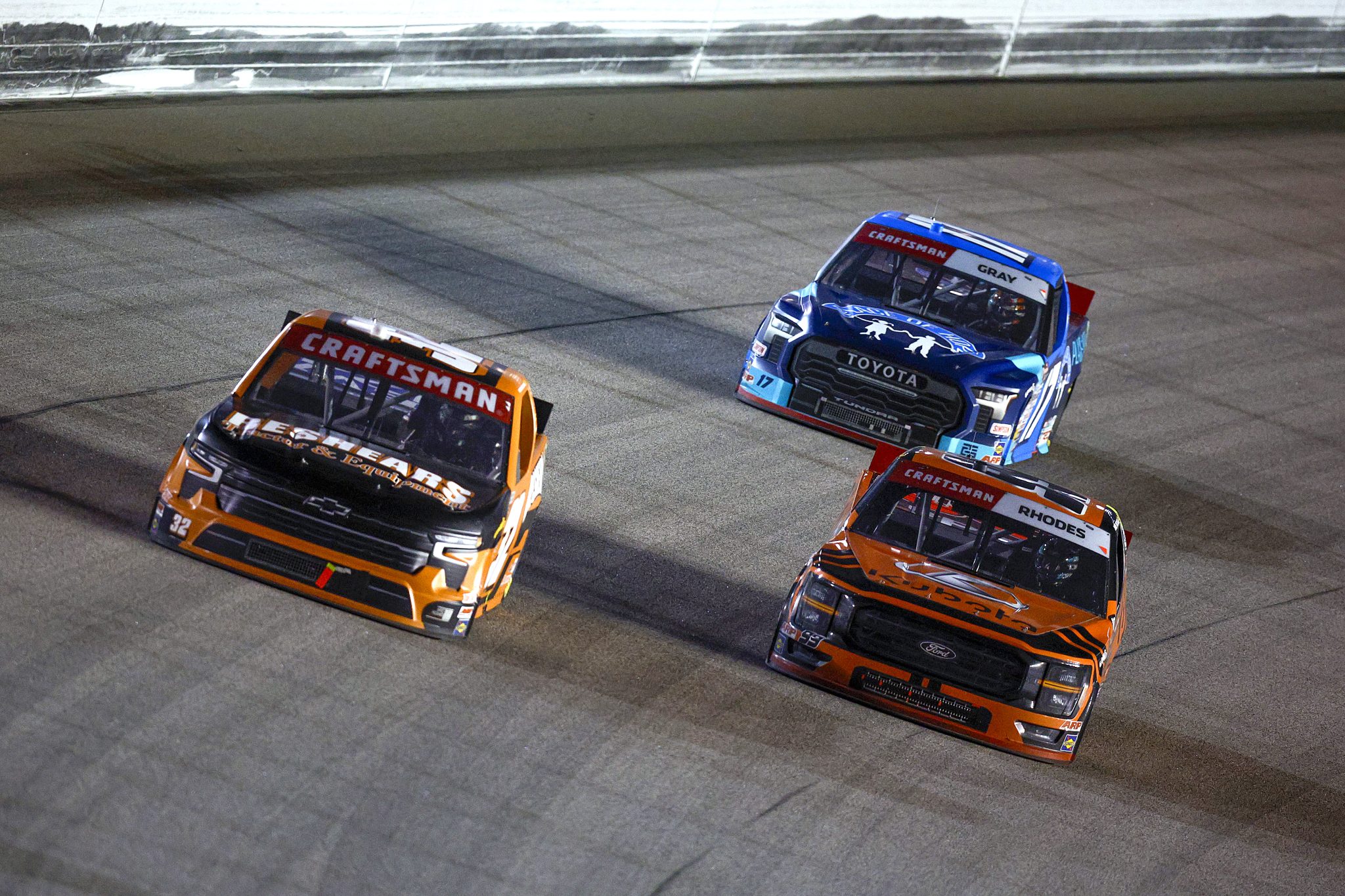 KANSAS CITY, KANSAS - SEPTEMBER 27: Ben Rhodes, driver of the #99 Kubota Ford, Bret Holmes, driver of the #32 Beshears Tractor & Equipment Chevrolet, and Taylor Gray, driver of the #17 Place of Hope Toyota, race during the NASCAR Craftsman Truck Series Kubota Tractor 200 at Kansas Speedway on September 27, 2024 in Kansas City, Kansas. (Photo by Sean Gardner/Getty Images) | Getty Images