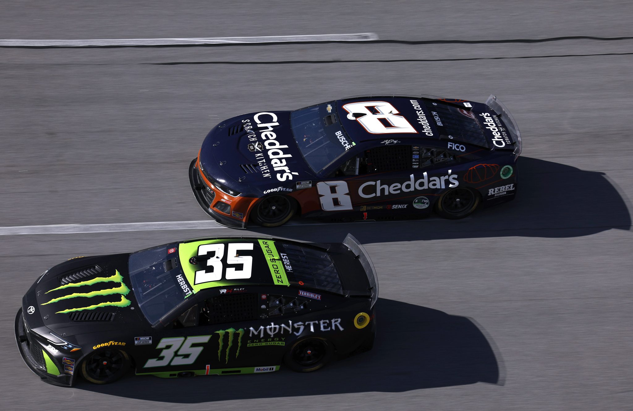 TALLADEGA, ALABAMA - OCTOBER 19: Riley Herbst, driver of the #35 Monster Energy Zero Sugar Toyota, and Kyle Busch, driver of the #8 Cheddar's Scratch Kitchen Chevrolet, race during the NASCAR Cup Series YellaWood 500 at Talladega Superspeedway on October 19, 2025 in Talladega, Alabama. (Photo by Sean Gardner/Getty Images) | Getty Images