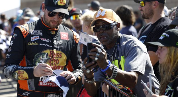 KANSAS CITY, KANSAS - SEPTEMBER 28: Chase Briscoe, driver of the #19 Bass Pro Shops Toyota, signs autographs for NASCAR fans on the grid prior to the NASCAR Cup Series Hollywood Casino 400 Presented by ESPN BET at Kansas Speedway on September 28, 2025 in Kansas City, Kansas. (Photo by Sean Gardner/Getty Images) | Getty Images