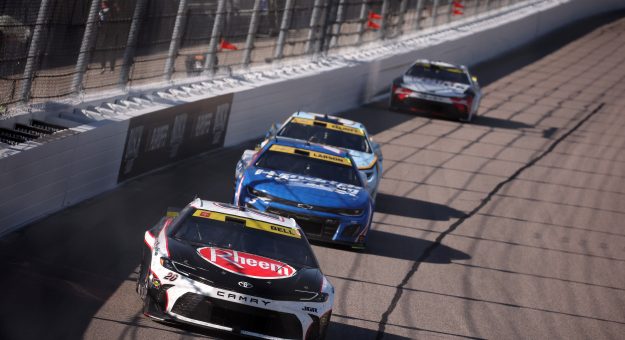 KANSAS CITY, KANSAS - SEPTEMBER 28: Christopher Bell, driver of the #20 Rheem Toyota, Kyle Larson, driver of the #5 HendrickCars.com Chevrolet, and Chase Elliott, driver of the #9 Kelley Blue Book Chevrolet, race during the NASCAR Cup Series Hollywood Casino 400 Presented by ESPN BET at Kansas Speedway on September 28, 2025 in Kansas City, Kansas. (Photo by Chris Graythen/Getty Images) | Getty Images