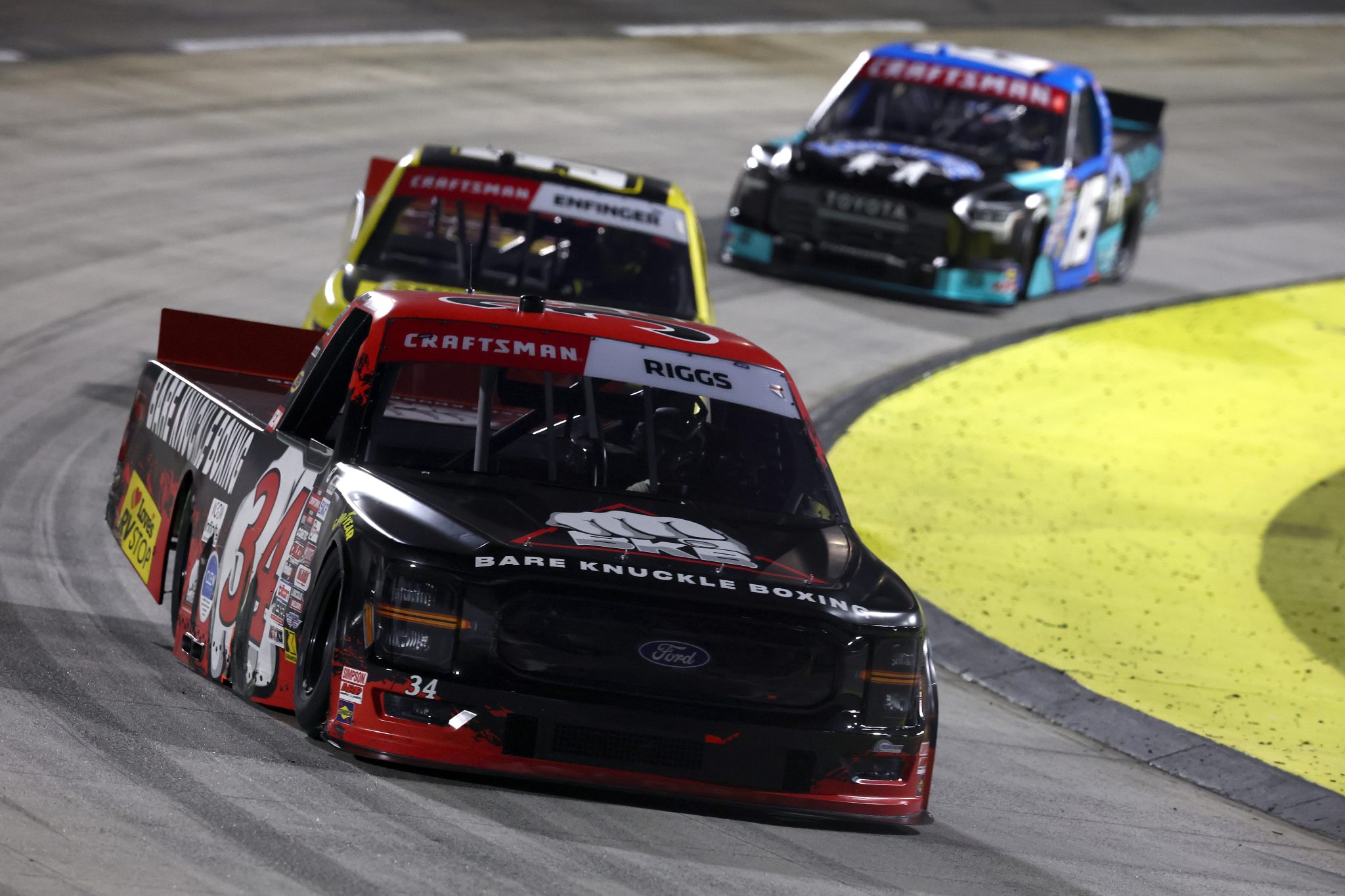 MARTINSVILLE, VIRGINIA - OCTOBER 24: Layne Riggs, driver of the #34 Bare Knuckle Boxing Ford, Grant Enfinger, driver of the #9 Champion Power Equipment Chevrolet, and Tanner Gray, driver of the #15 Place of Hope Toyota, race during the NASCAR Craftsman Truck Slim Jim 200 at Martinsville Speedway on October 24, 2025 in Martinsville, Virginia. (Photo by Jared C. Tilton/Getty Images) | Getty Images