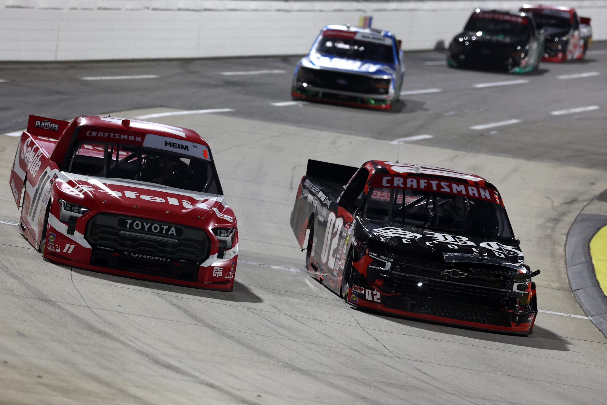 MARTINSVILLE, VIRGINIA - OCTOBER 24: Corey Heim, driver of the #11 Safelite Toyota, and Logan Bearden, driver of the #02 SBG Records Chevrolet, race during the NASCAR Craftsman Truck Slim Jim 200 at Martinsville Speedway on October 24, 2025 in Martinsville, Virginia. (Photo by David Jensen/Getty Images) | Getty Images