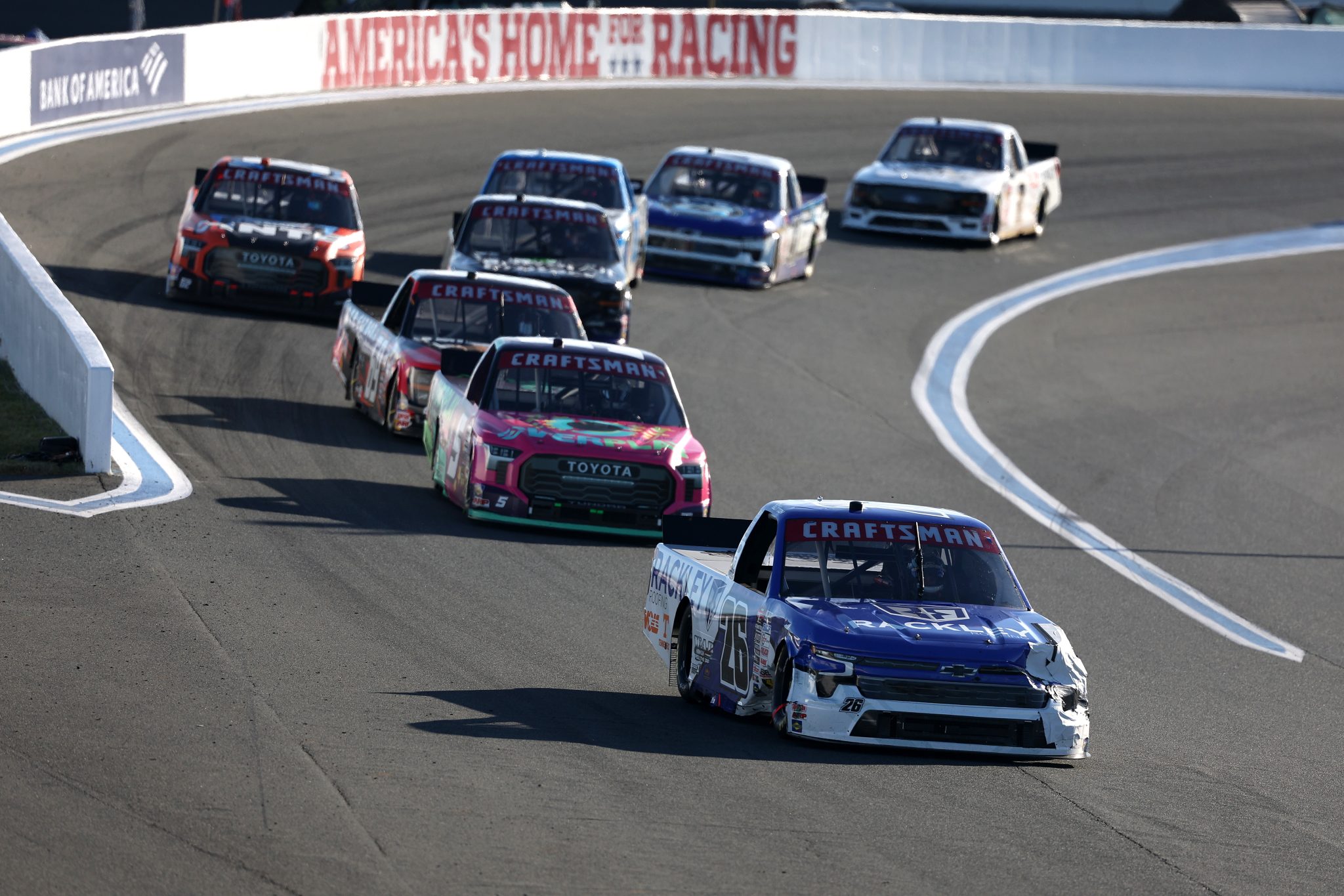 CONCORD, NORTH CAROLINA - OCTOBER 03: Dawson Sutton, driver of the #26 Rackley Roofing Chevrolet, Toni Breidinger, driver of the #5 Overplay Toyota, and Tyler Tomassi, driver of the #69 Tomassi Law LLC Ford, race during the NASCAR Craftsman Truck Series EcoSave 250 at Charlotte Motor Speedway on October 03, 2025 in Concord, North Carolina. (Photo by David Jensen/Getty Images) | Getty Images