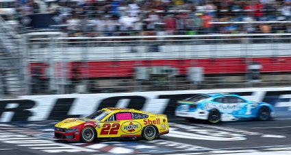 CONCORD, NORTH CAROLINA - OCTOBER 05: Joey Logano, driver of the #22 Shell Pennzoil Ford, crosses the finish line ahead of Ross Chastain, driver of the #1 Busch Light Chevrolet, who finishes in reverse after an on-track incident after an on-track incident to end the NASCAR Cup Series Bank of America ROVAL 400 at Charlotte Motor Speedway on October 05, 2025 in Concord, North Carolina. (Photo by Jared C. Tilton/Getty Images) | Getty Images