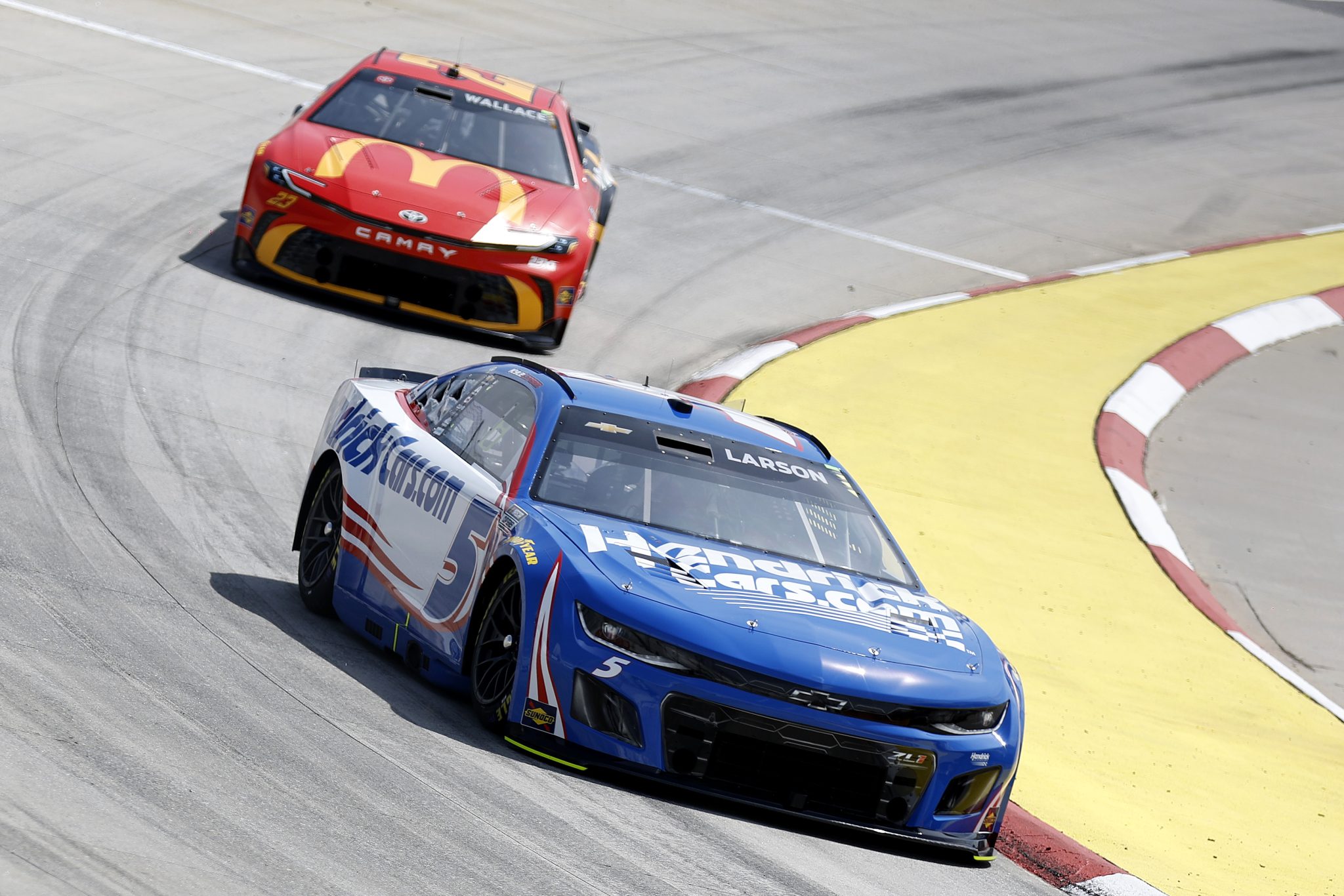 MARTINSVILLE, VIRGINIA - MARCH 29: Kyle Larson, driver of the #5 HendrickCars.com Chevrolet, and Bubba Wallace, driver of the #23 McDonald's Toyota, drive during practice for the NASCAR Cup Series Cook Out 400 at Martinsville Speedway on March 29, 2025 in Martinsville, Virginia. (Photo by Logan Riely/Getty Images) | Getty Images