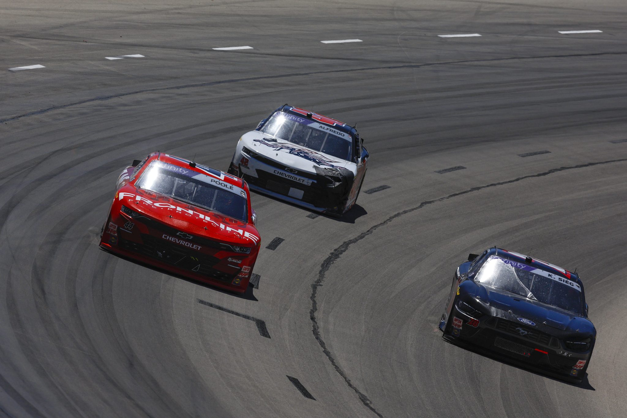 FORT WORTH, TEXAS - MAY 03: Brennan Poole, driver of the #44 Frontline Fire Protection Chevrolet, Kyle Sieg, driver of the #28 Sci Aps Ford, and Anthony Alfredo, driver of the #42 Randco Chevrolet, race during the NASCAR Xfinity Series Andy's Frozen Custard 300 at Texas Motor Speedway on May 03, 2025 in Fort Worth, Texas. (Photo by Sean Gardner/Getty Images) | Getty Images