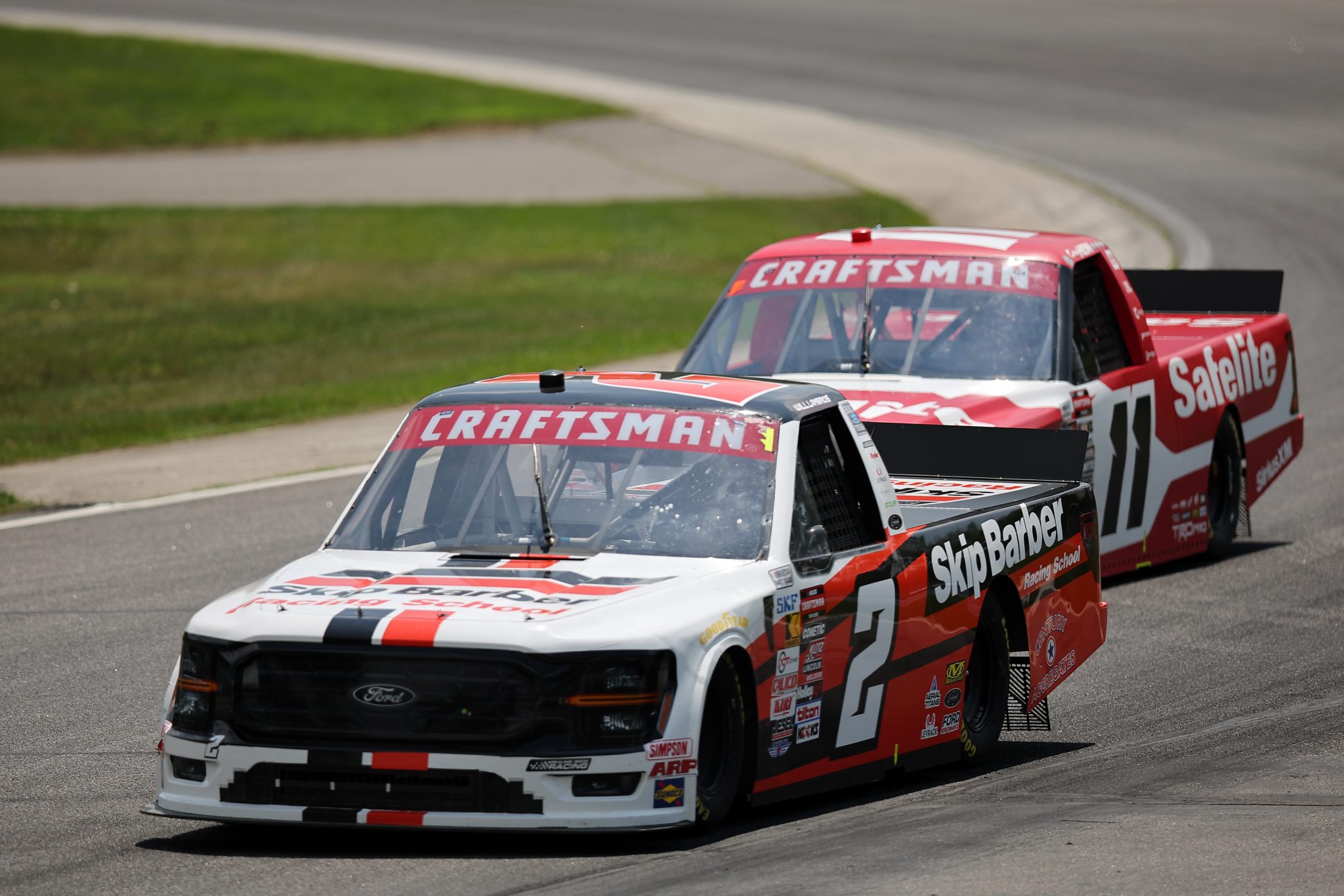 LAKEVILLE, CONNECTICUT - JUNE 28: William Lambros, driver of the #2 Skip Barber Ford, and Corey Heim, driver of the #11 Safelite Toyota, race during the NASCAR Craftsman Truck Series LiUNA! 150 at Lime Rock Park on June 28, 2025 in Lakeville, Connecticut. (Photo by Jonathan Bachman/Getty Images) | Getty Images