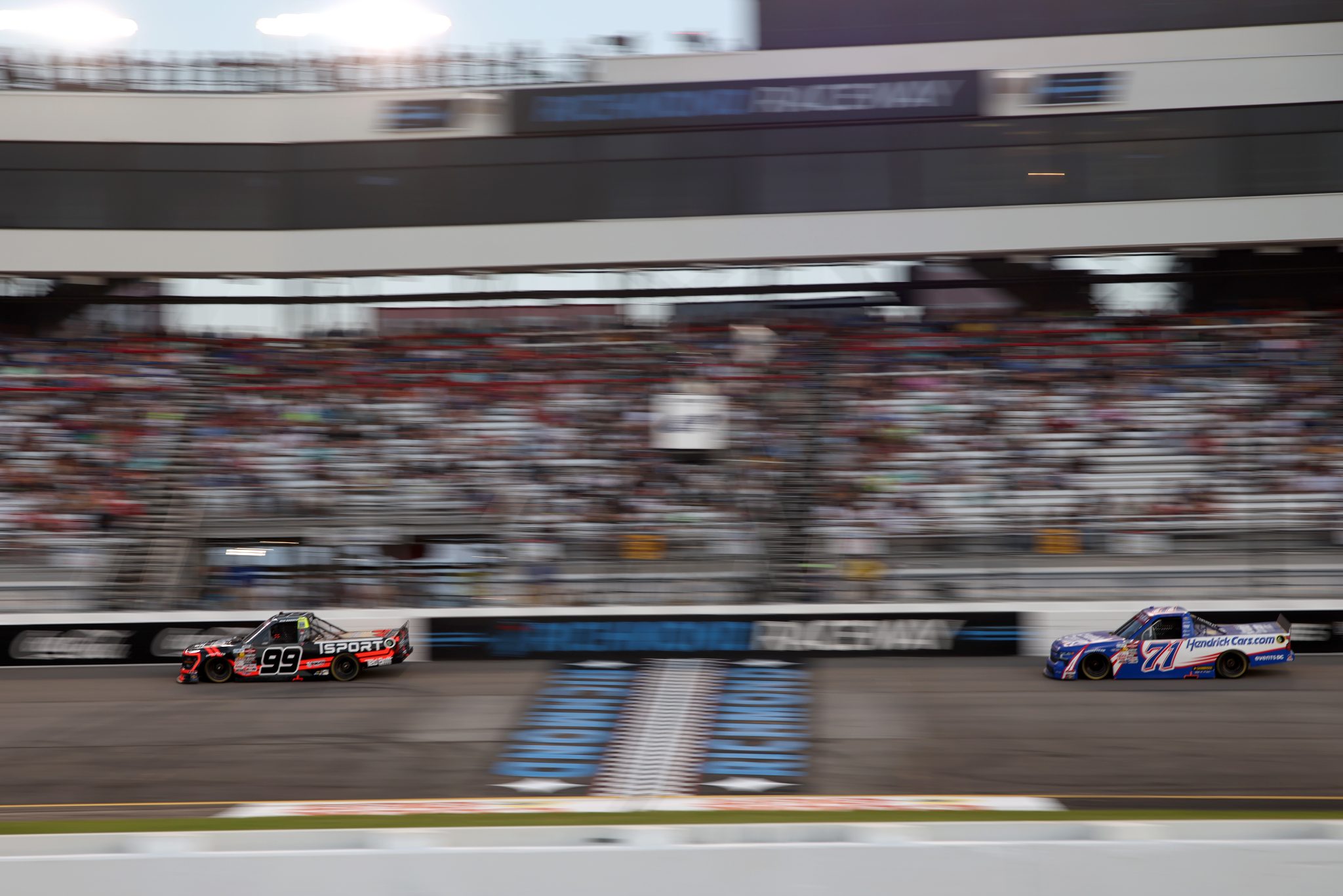 RICHMOND, VIRGINIA - AUGUST 15: Ben Rhodes, driver of the #99 TSPORT Trucks Ford, and Rajah Caruth, driver of the #71 HendrickCars.com Chevrolet, race during the NASCAR Craftsman Truck Series eero 250 at Richmond Raceway on August 15, 2025 in Richmond, Virginia. (Photo by Samuel Corum/Getty Images) | Getty Images