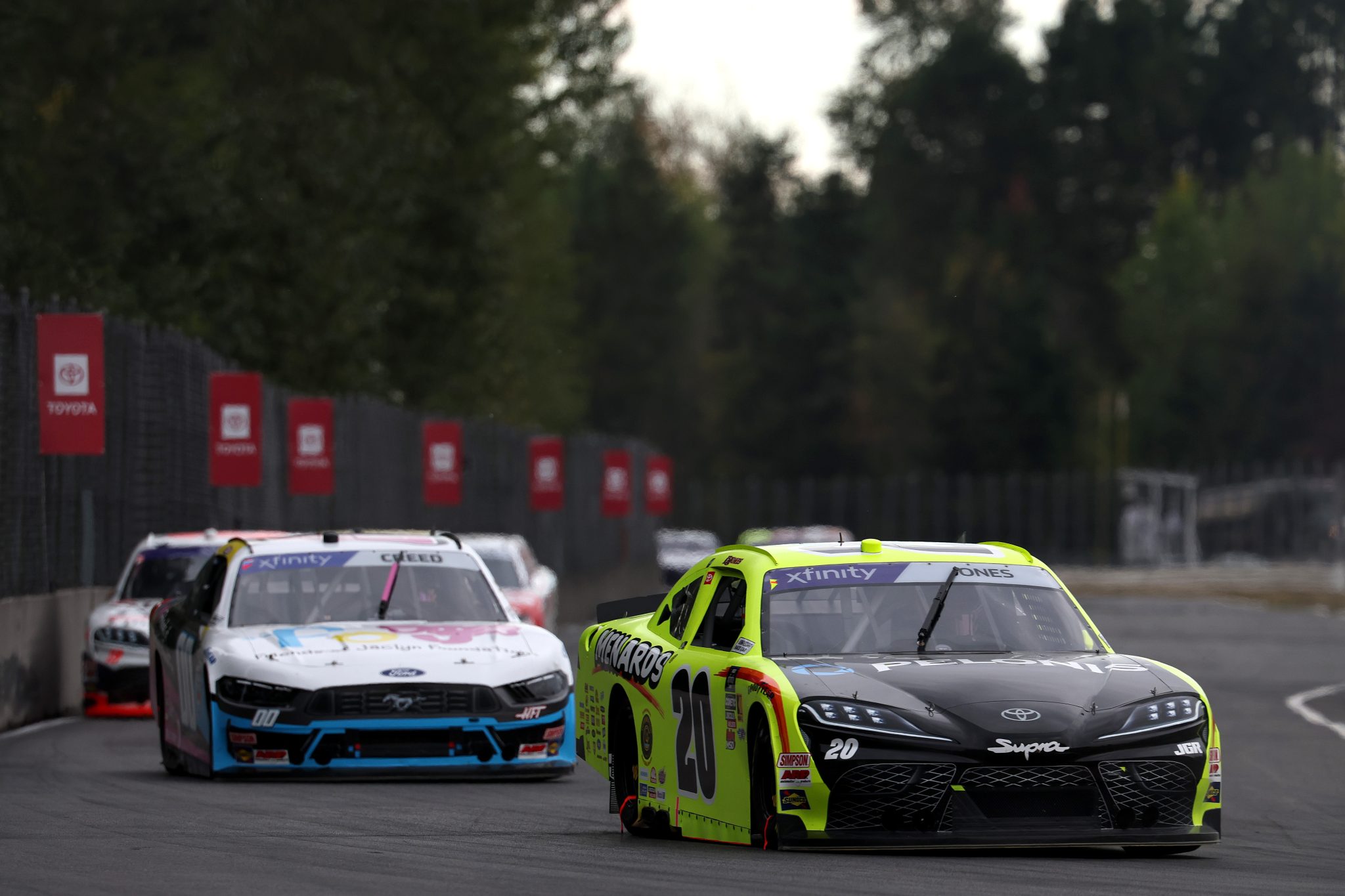 PORTLAND, OREGON - AUGUST 30: Brandon Jones, driver of the #20 Menards/Pelonis Toyota, and Sheldon Creed, driver of the #00 Friends of Jaclyn Ford, race during the NASCAR Xfinity Series Pacific Office Automation 147 at Portland International Raceway on August 30, 2025 in Portland, Oregon. (Photo by David Jensen/Getty Images) | Getty Images