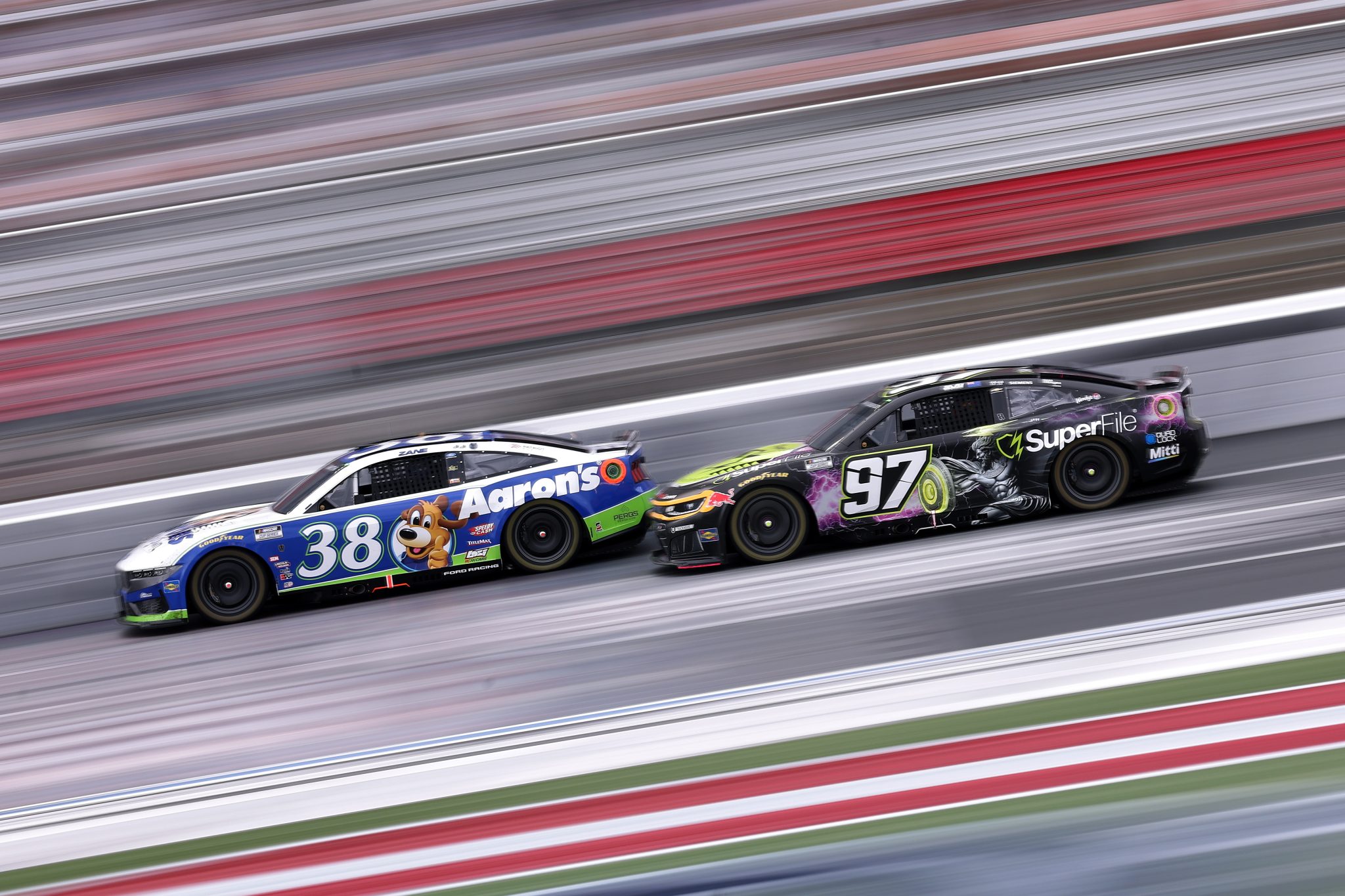 CONCORD, NORTH CAROLINA - OCTOBER 11: Zane Smith, driver of the #38 Aaron's Rent To Own Ford, and Shane Van Gisbergen, driver of the #97 SuperFile Chevrolet, race during the NASCAR Cup Series Bank of America 400 at Charlotte Motor Speedway on October 11, 2026 in Concord, North Carolina. (Photo by David Jensen/Getty Images) | Getty Images