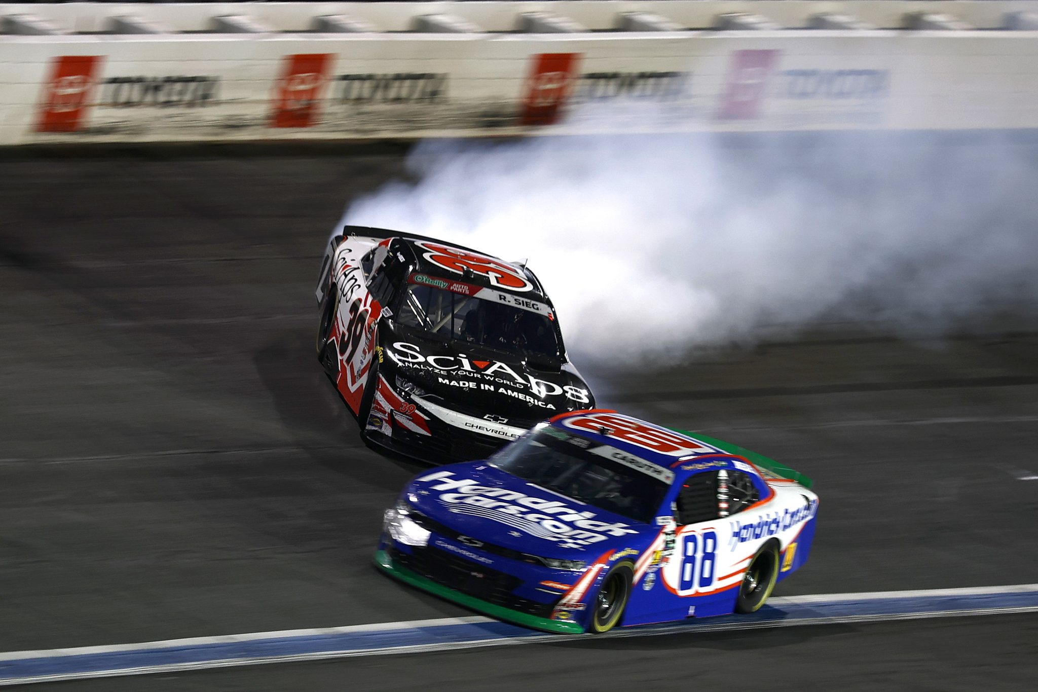 CONCORD, NORTH CAROLINA - OCTOBER 11: Ryan Sieg, driver of the #39 SciAps Chevrolet, spins ahead of Rajah Caruth, driver of the #88 HendrickCars.com Chevrolet, after an on-track incident as during the NASCAR O'Reilly Auto Parts Series Blue Cross NC 300 at Charlotte Motor Speedway on October 11, 2026 in Concord, North Carolina. (Photo by Jared C. Tilton/Getty Images) | Getty Images