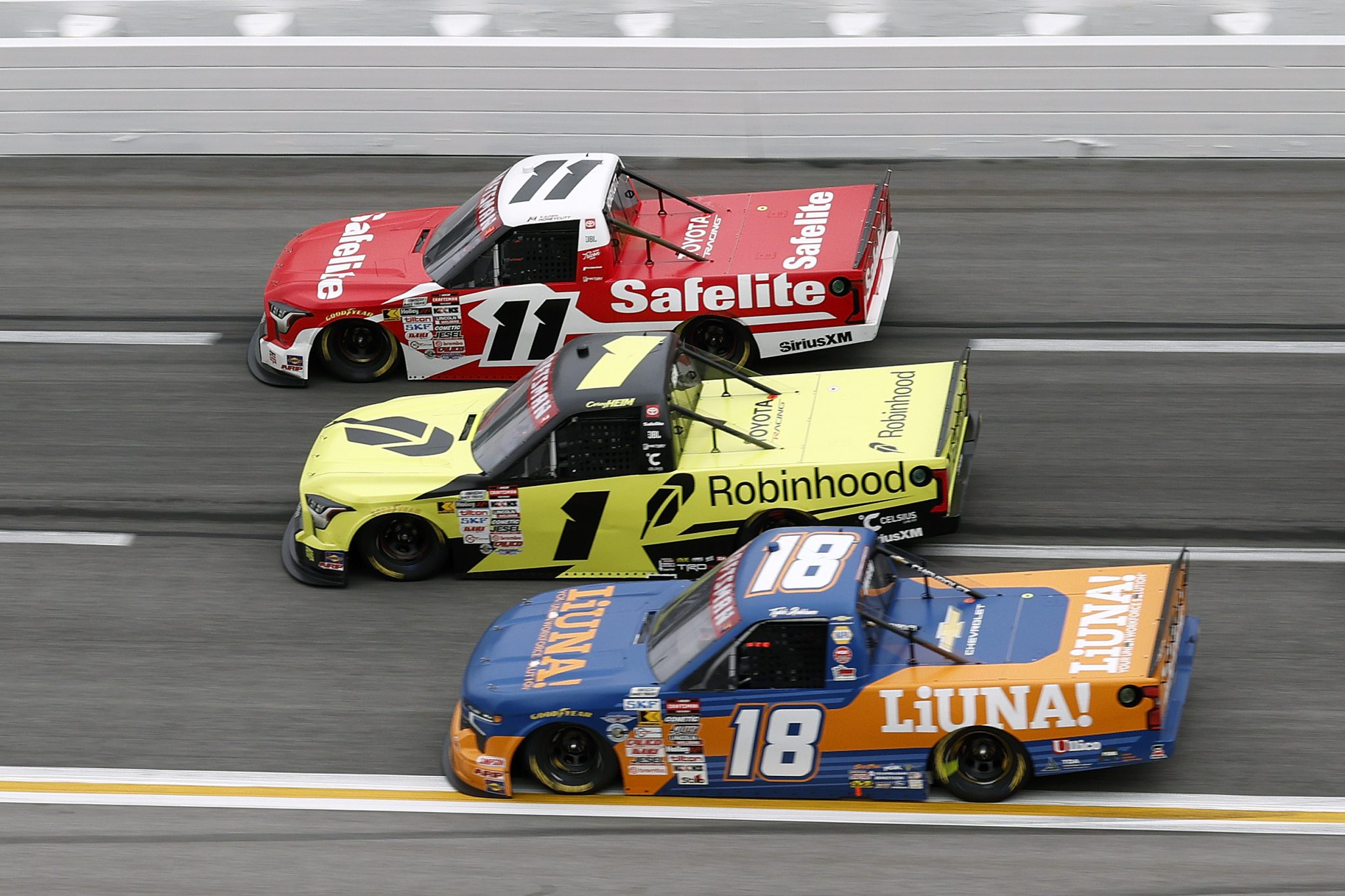 HAMPTON, GEORGIA - FEBRUARY 21: Kaden Honeycutt, driver of the #11 Safelite Toyota, Corey Heim, driver of the #1 Robinhood Toyota, and Tyler Ankrum, driver of the #18 LiUNA! Chevrolet, race during the NASCAR Craftsman Truck Series Fr8 Racing 208 at Echo Park Speedway on February 21, 2026 in Hampton, Georgia. (Photo by Sean Gardner/Getty Images) | Getty Images