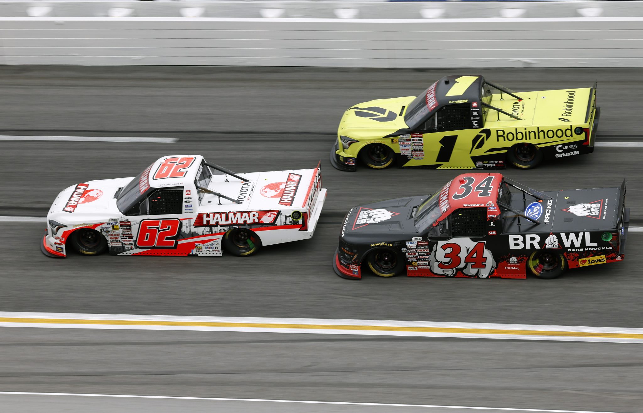 HAMPTON, GEORGIA - FEBRUARY 21: John Hunter Nemechek, driver of the #62 Halmar International Toyota, Layne Riggs, driver of the #34 BKB Bare Knuckle Boxing Ford, and Corey Heim, driver of the #1 Robinhood Toyota, race during the NASCAR Craftsman Truck Series Fr8 Racing 208 at Echo Park Speedway on February 21, 2026 in Hampton, Georgia. (Photo by Sean Gardner/Getty Images) | Getty Images