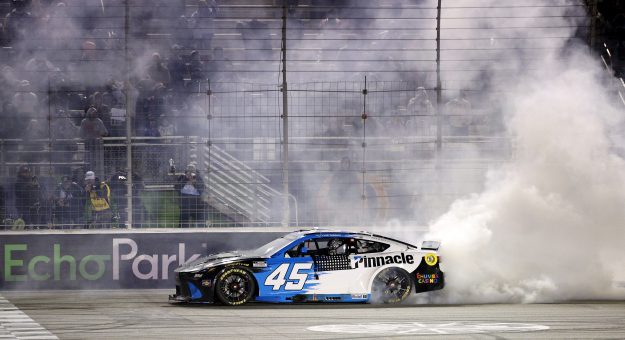 HAMPTON, GEORGIA - FEBRUARY 22: Tyler Reddick, driver of the #45 Pinnacle Toyota, celebrates with a burnout after winning the NASCAR Cup Series Autotrader 400 at Echo Park Speedway on February 22, 2026 in Hampton, Georgia. (Photo by Sean Gardner/Getty Images) | Getty Images