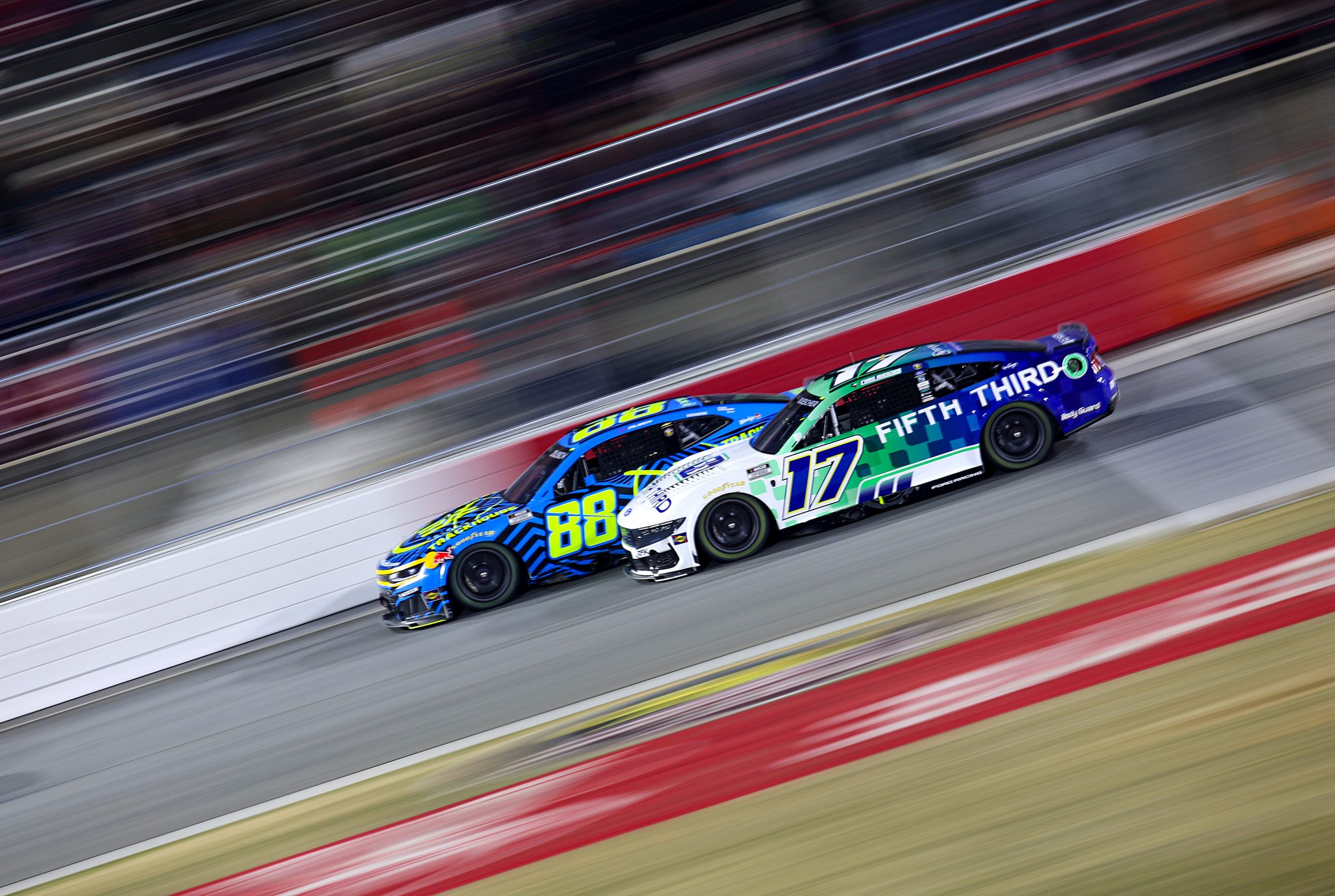WINSTON SALEM, NORTH CAROLINA - FEBRUARY 04: Connor Zilisch, driver of the #88 Trackhouse Chevrolet, and Chris Buescher, driver of the #17 Fifth Third Bank Ford, race during the Cook Out Clash at Bowman Gray Stadium at Bowman Gray Stadium on February 04, 2026 in Winston Salem, North Carolina. (Photo by Jonathan Bachman/Getty Images) | Getty Images