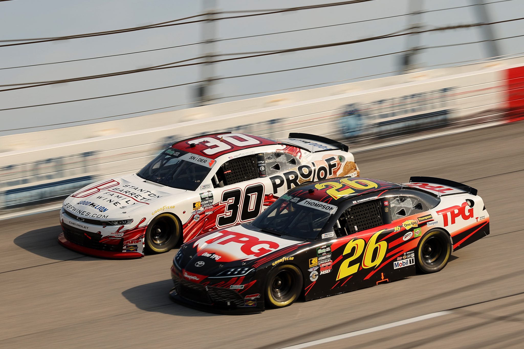 DARLINGTON, SOUTH CAROLINA - MARCH 21: Dean Thompson, driver of the #26 Thompson Pipe Group Toyota, and Myatt Snider, driver of the #30 Barrett Wines/Proof Ice Cream Chevrolet, race during the NASCAR O'Reilly Auto Parts Series Sport Clips Haircuts VFW Help a Hero 200 at Darlington Raceway on March 21, 2026 in Darlington, South Carolina. (Photo by Jonathan Bachman/Getty Images) | Getty Images