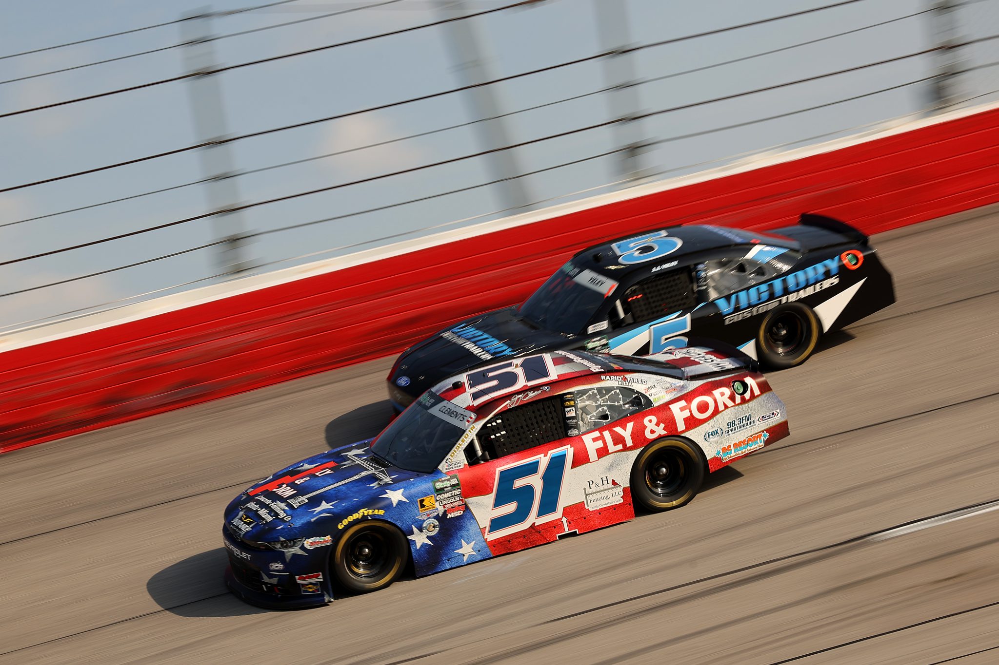 DARLINGTON, SOUTH CAROLINA - MARCH 21: Jeremy Clements, driver of the #51 Fly and Form Structures Chevrolet, and JJ Yeley, driver of the #5 Victory Custom Trailers Ford, race during the NASCAR O'Reilly Auto Parts Series Sport Clips Haircuts VFW Help a Hero 200 at Darlington Raceway on March 21, 2026 in Darlington, South Carolina. (Photo by Jonathan Bachman/Getty Images) | Getty Images