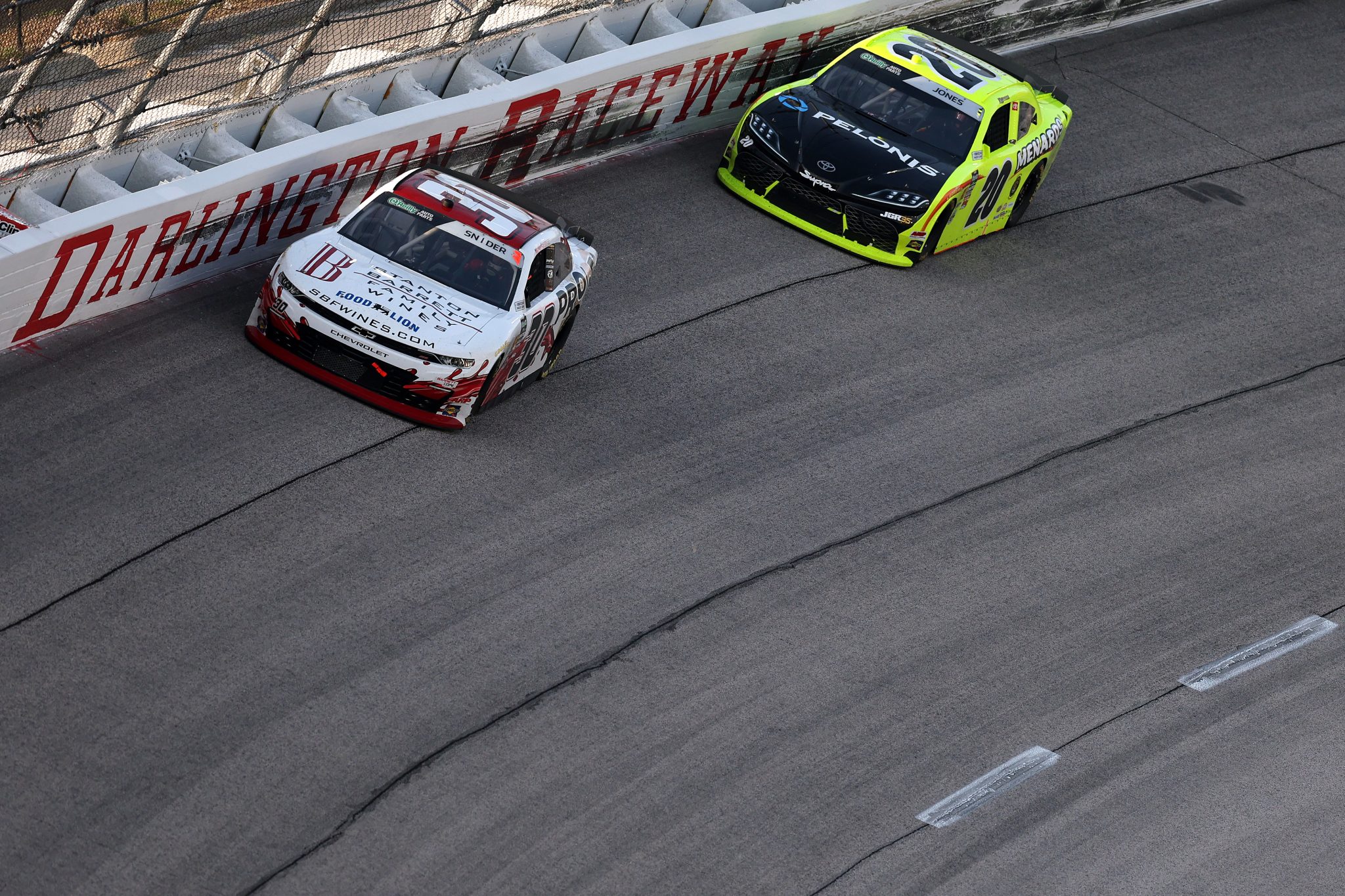DARLINGTON, SOUTH CAROLINA - MARCH 21: Myatt Snider, driver of the #30 Barrett Wines/Proof Ice Cream Chevrolet, and Brandon Jones, driver of the #20 Menards/Pelonis Toyota, race during the NASCAR O'Reilly Auto Parts Series Sport Clips Haircuts VFW Help a Hero 200 at Darlington Raceway on March 21, 2026 in Darlington, South Carolina. (Photo by David Jensen/Getty Images) | Getty Images