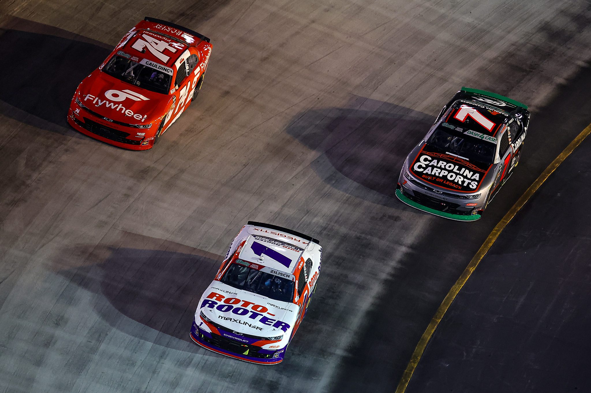 BRISTOL, TENNESSEE - APRIL 11: Connor Zilisch, driver of the #1 Roto-Rooter Chevrolet, Gray Gaulding, driver of the #74 Flywheel Chevrolet, and Justin Allgaier, driver of the #7 Carolina Carports Chevrolet, race during the NASCAR O'Reilly Auto Parts Series Suburban Propane 300 at Bristol Motor Speedway on April 11, 2026 in Bristol, Tennessee. (Photo by Jonathan Bachman/Getty Images) | Getty Images