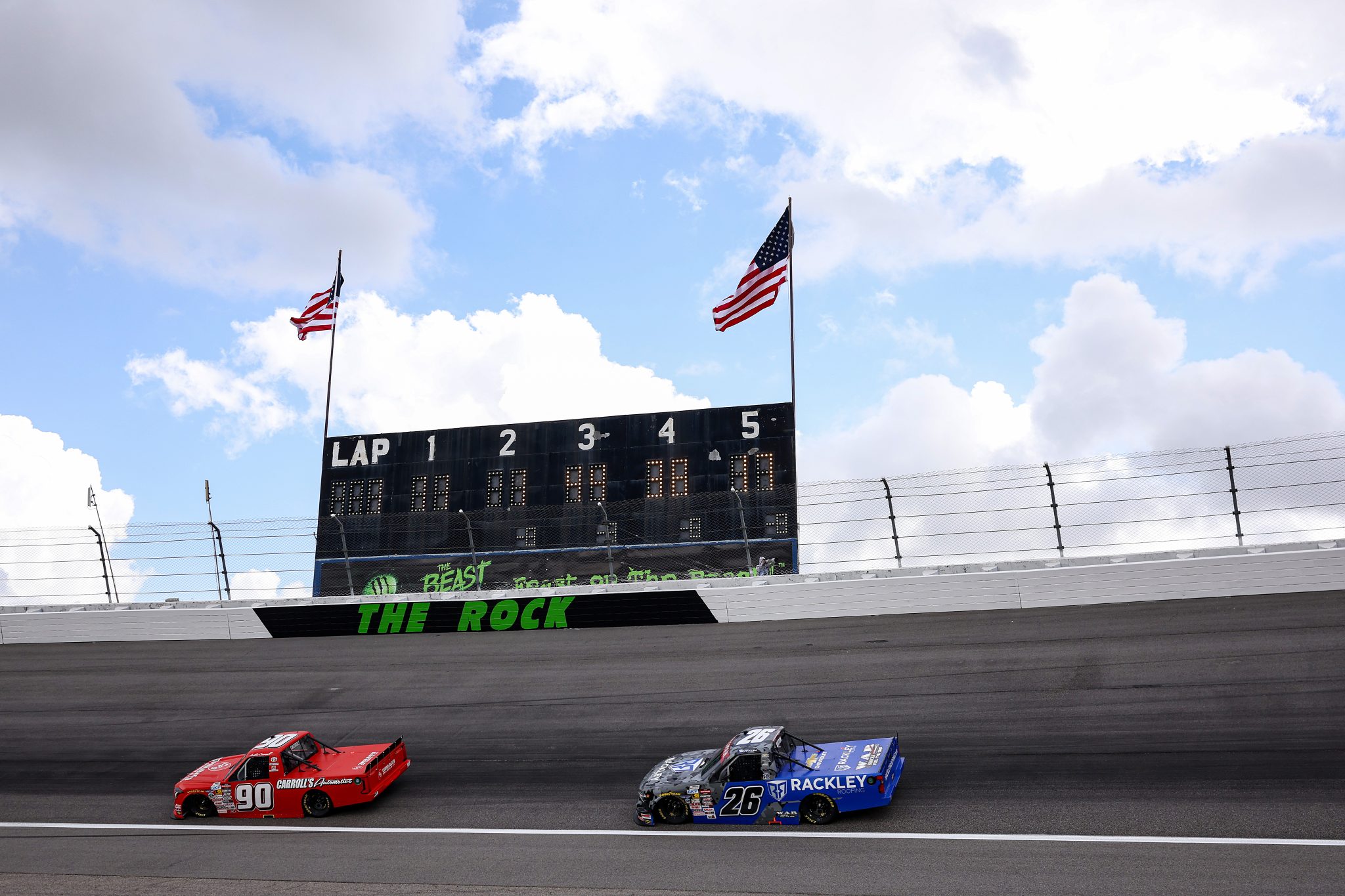 ROCKINGHAM, NORTH CAROLINA - APRIL 03: Justin Carroll, driver of the #90 Carroll's Automotive Toyota, and Dawson Sutton, driver of the #26 WAR Shocks/Rackley Roofing Chevrolet, drive during practice for the NASCAR Craftsman Truck Series Black's Tire 200 at Rockingham Speedway on April 03, 2026 in Rockingham, North Carolina. (Photo by James Gilbert/Getty Images) | Getty Images